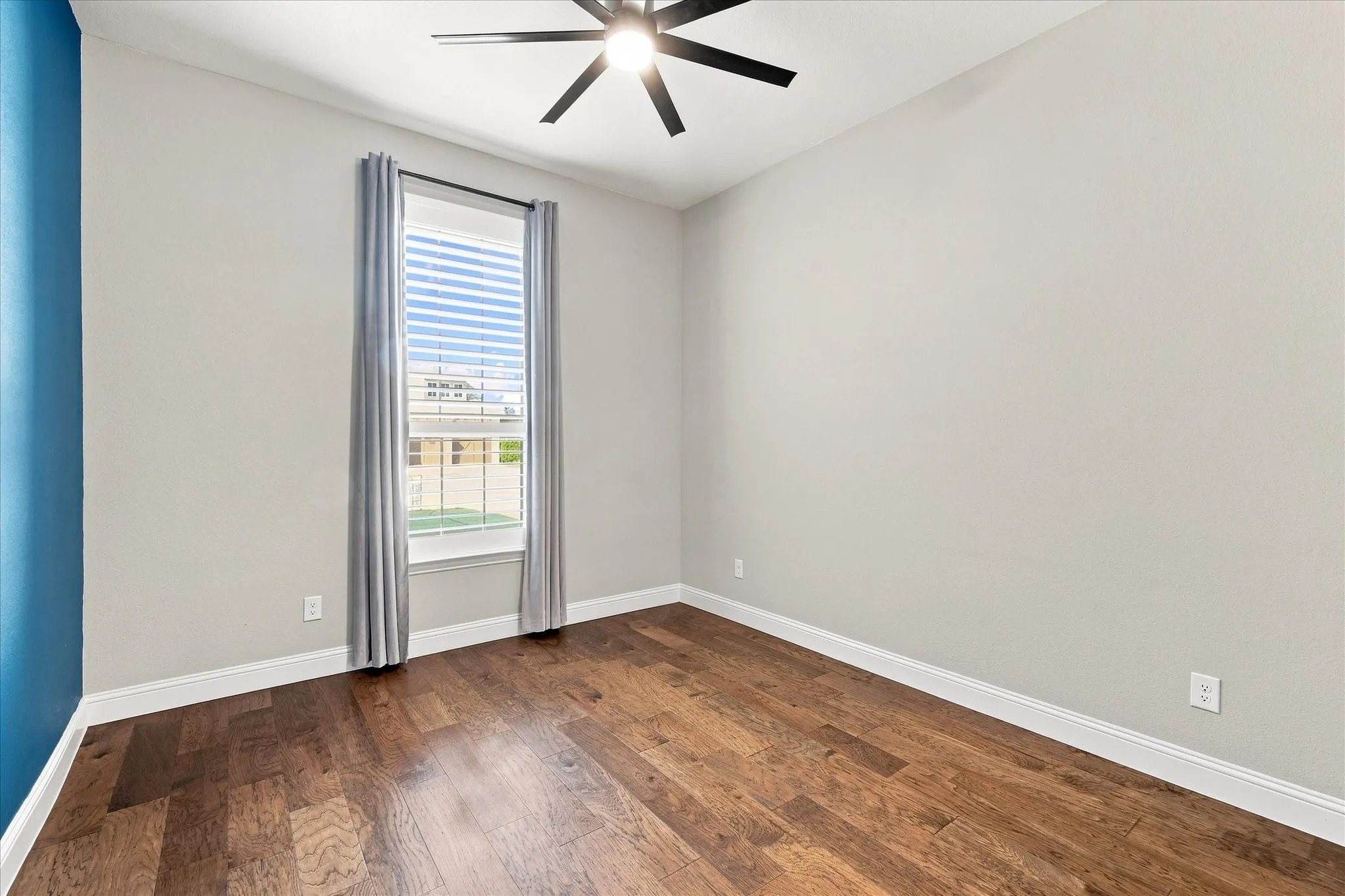 Wood-finish flooring, ceiling fan, window with blinds, and painted walls