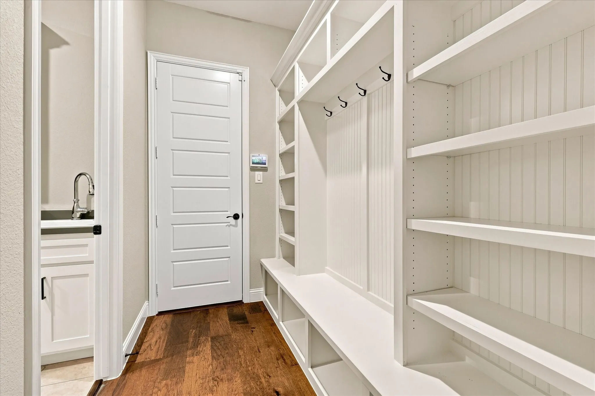 Built-in storage solutions with shelving, coat hooks, and bench seating