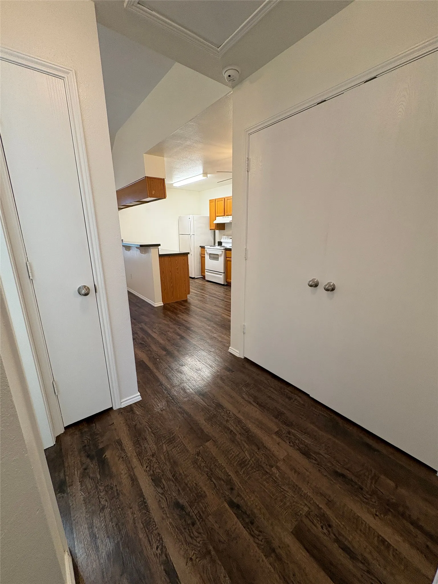 Wood-finish flooring throughout, white interior doors, and a built-in breakfast bar with a dark countertop
