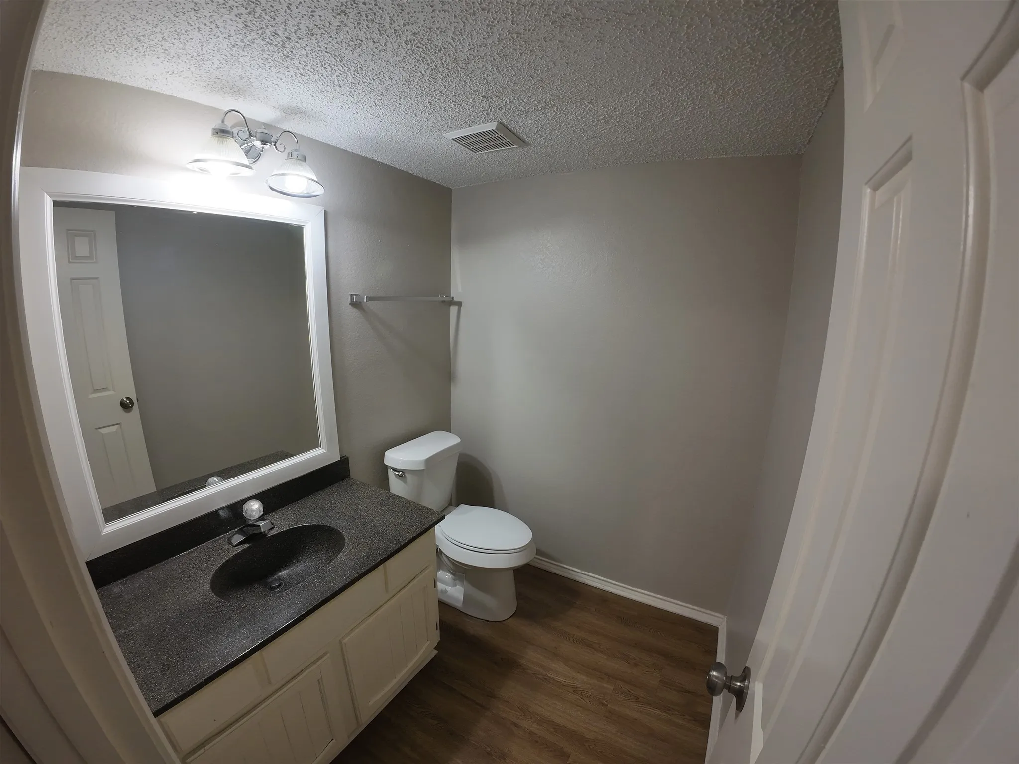 Vanity with an integrated sink, polished chrome faucet, and overhead lighting