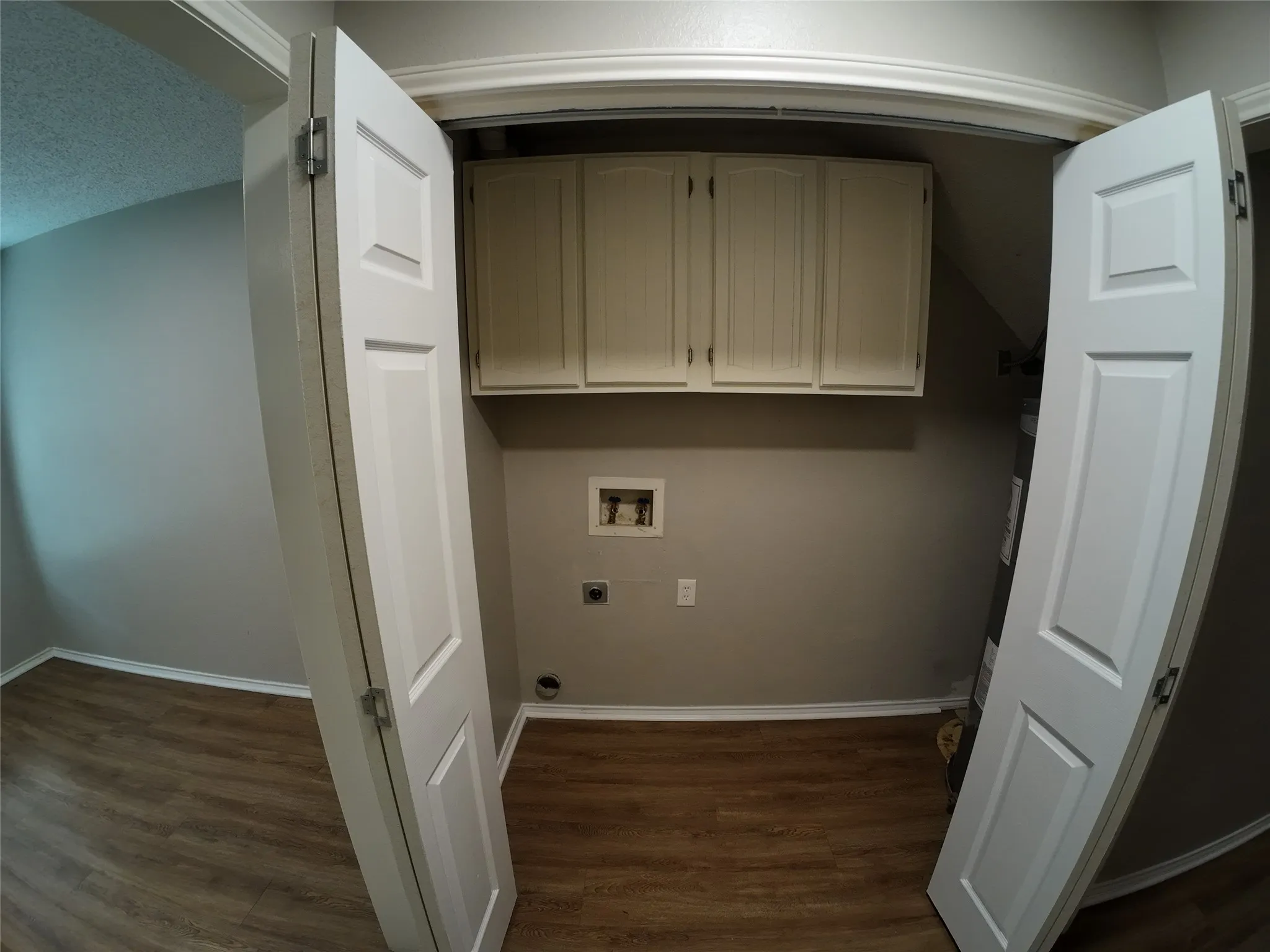 Built-in overhead cabinetry, wood-finish flooring, and crown molding
