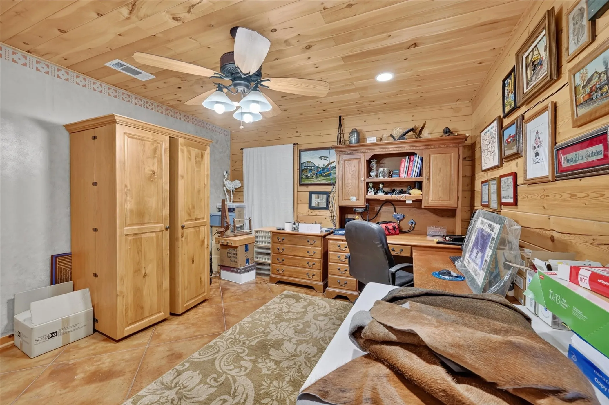 Wood paneling, wood-finish ceiling, tile flooring, built-in cabinetry, ceiling fan with integrated lighting