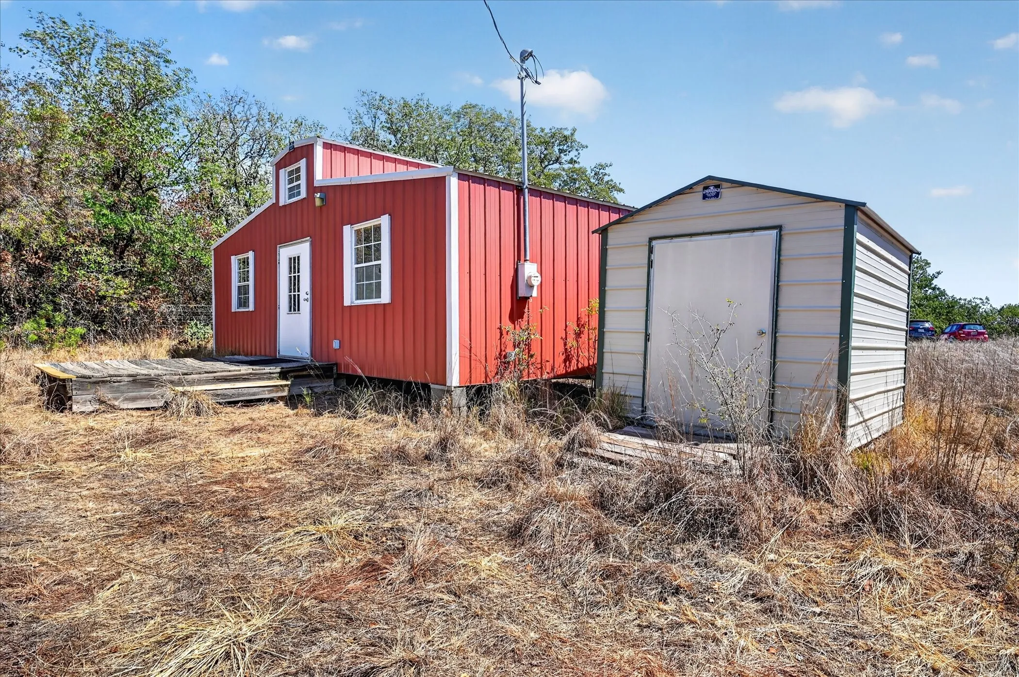 Red siding exterior with white trim windows and a white entry door