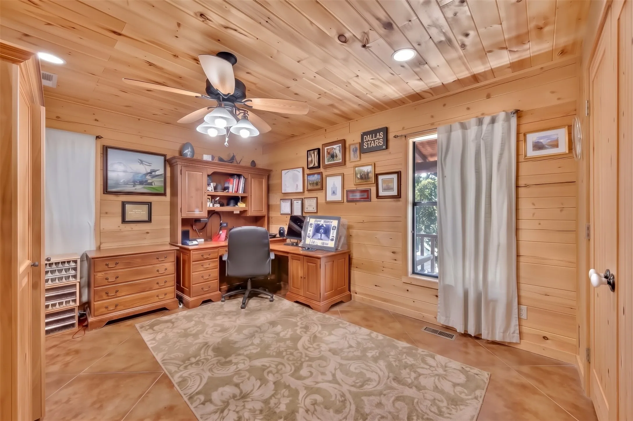 Wood-paneled walls and ceiling, recessed lighting, and a ceiling fan with light fixture