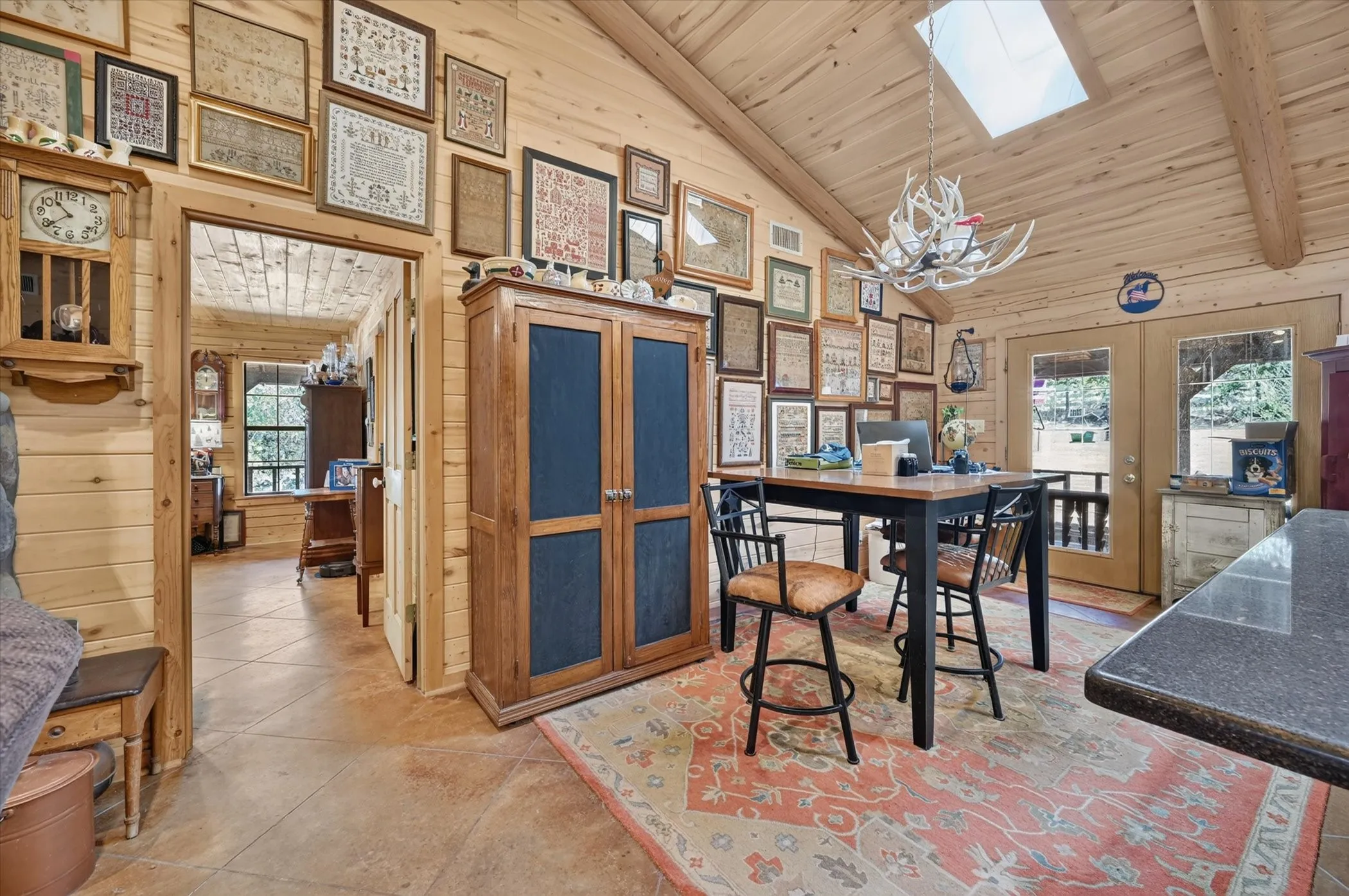 Vaulted wood-paneled ceiling with a skylight, wood-planked walls, and tile flooring
