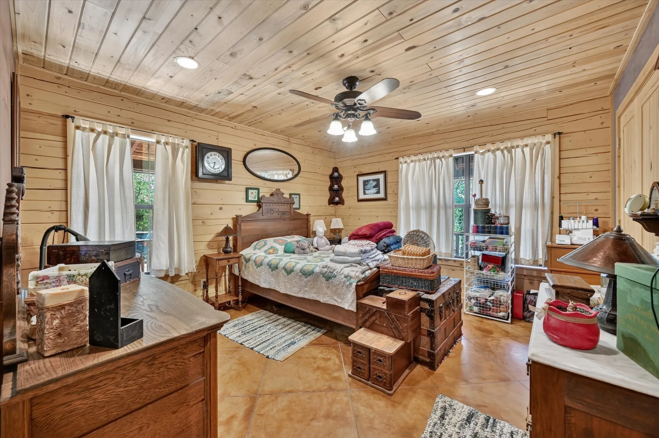 Wood-paneled walls and ceiling, recessed lighting, ceiling fan, and stained concrete flooring