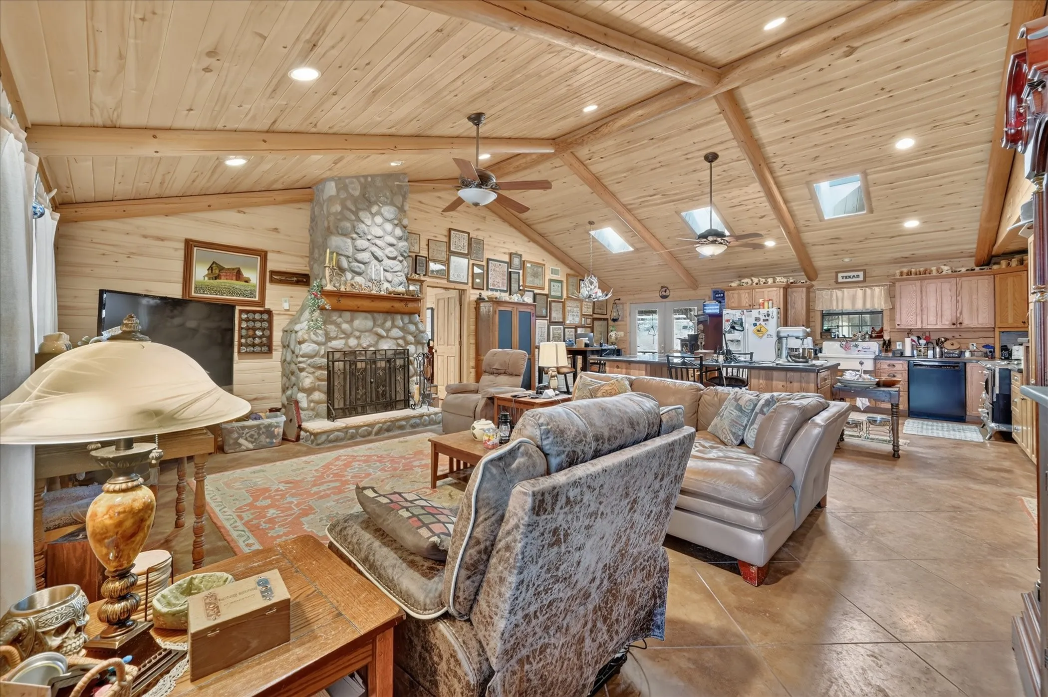 Vaulted wood-paneled ceilings with exposed beams, skylights, and recessed lighting