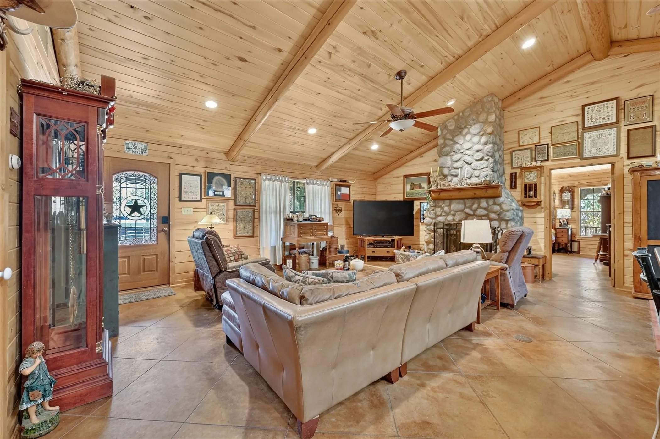 Vaulted wood-paneled ceilings with exposed beams, recessed lighting, and a ceiling fan