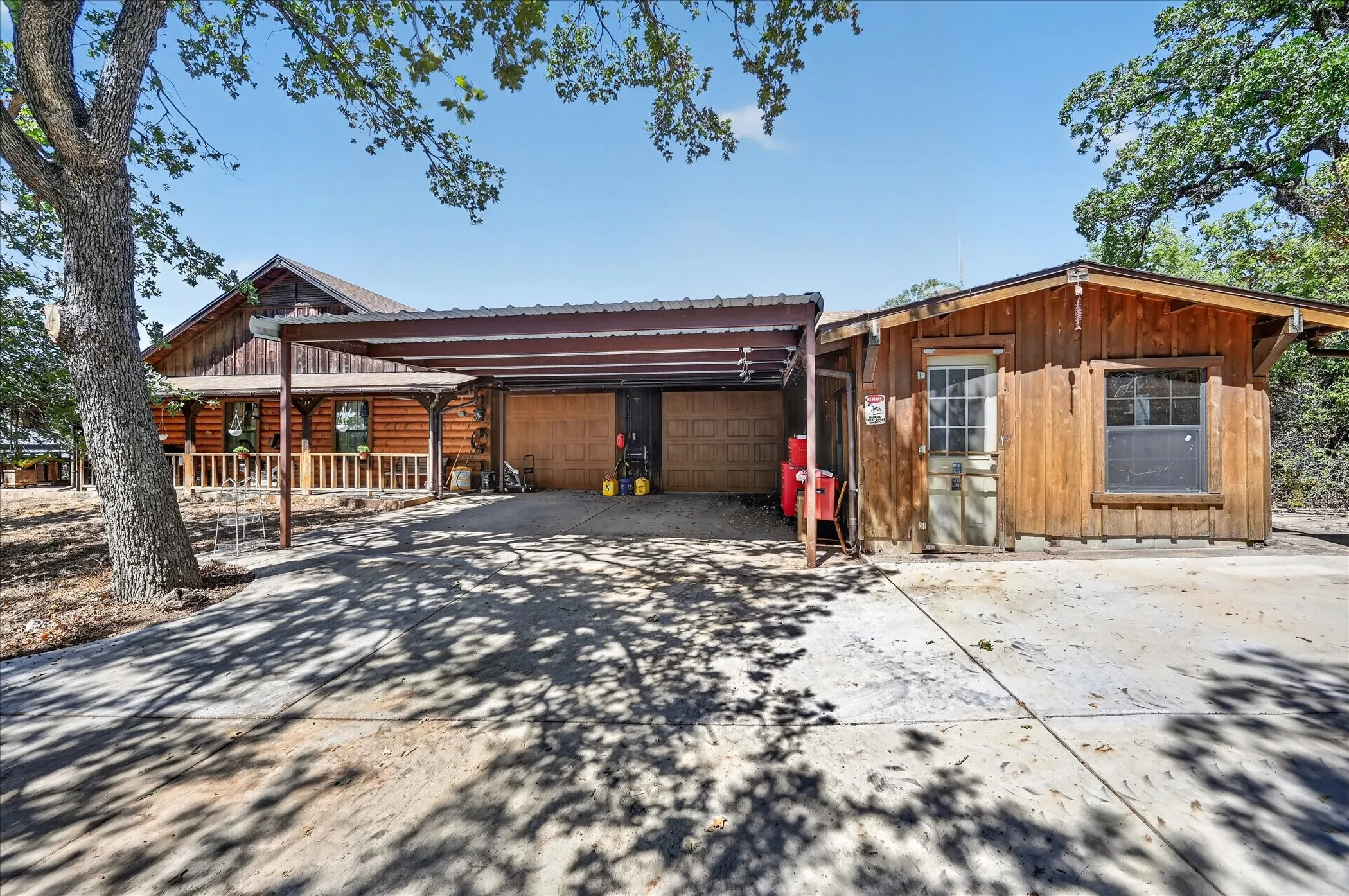 Wood-sided main residence with a covered front porch and a covered carport