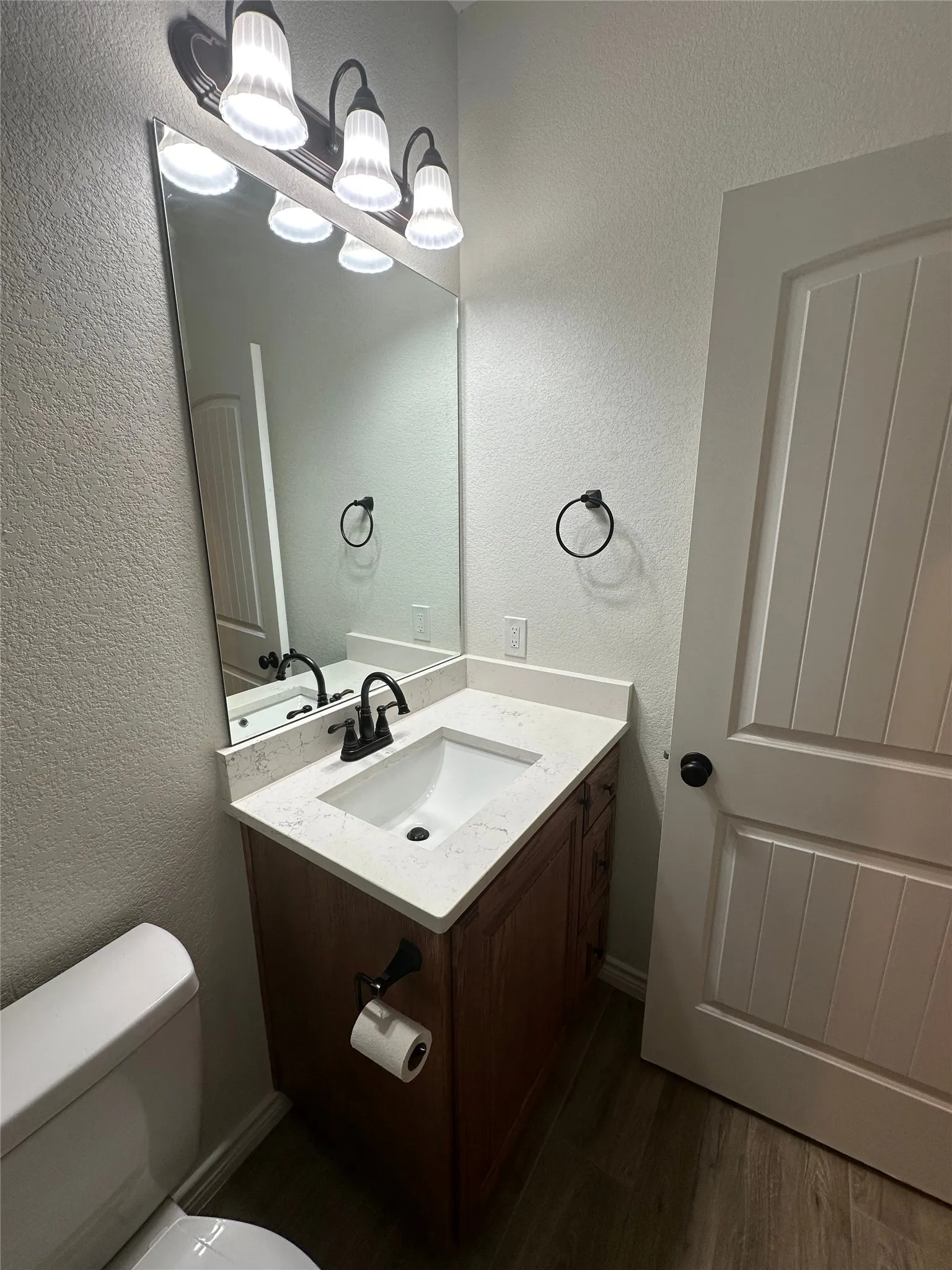 Vanity with a solid surface countertop, an undermount sink, and a matte black faucet
