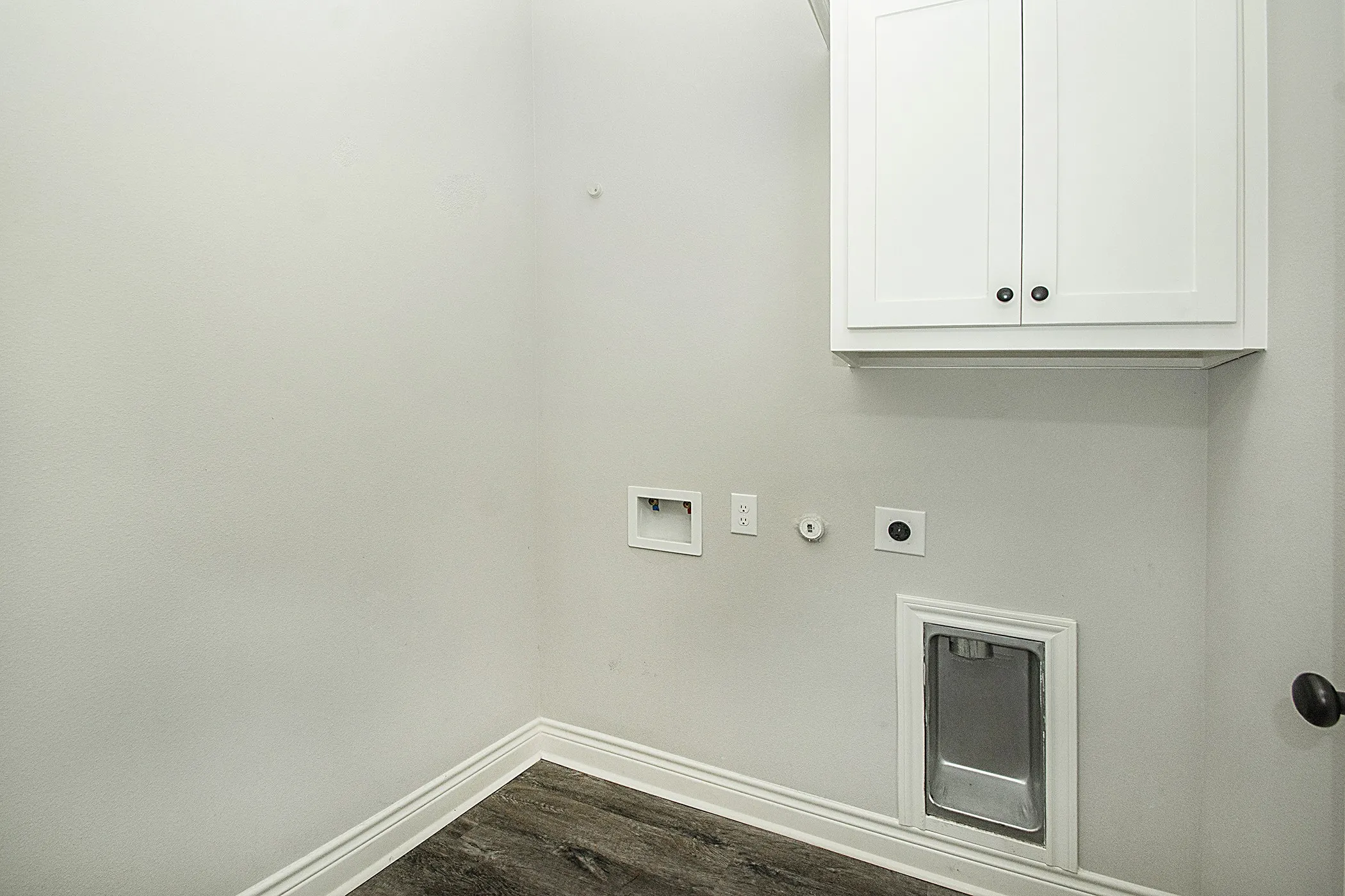 Upper white cabinetry with dark hardware