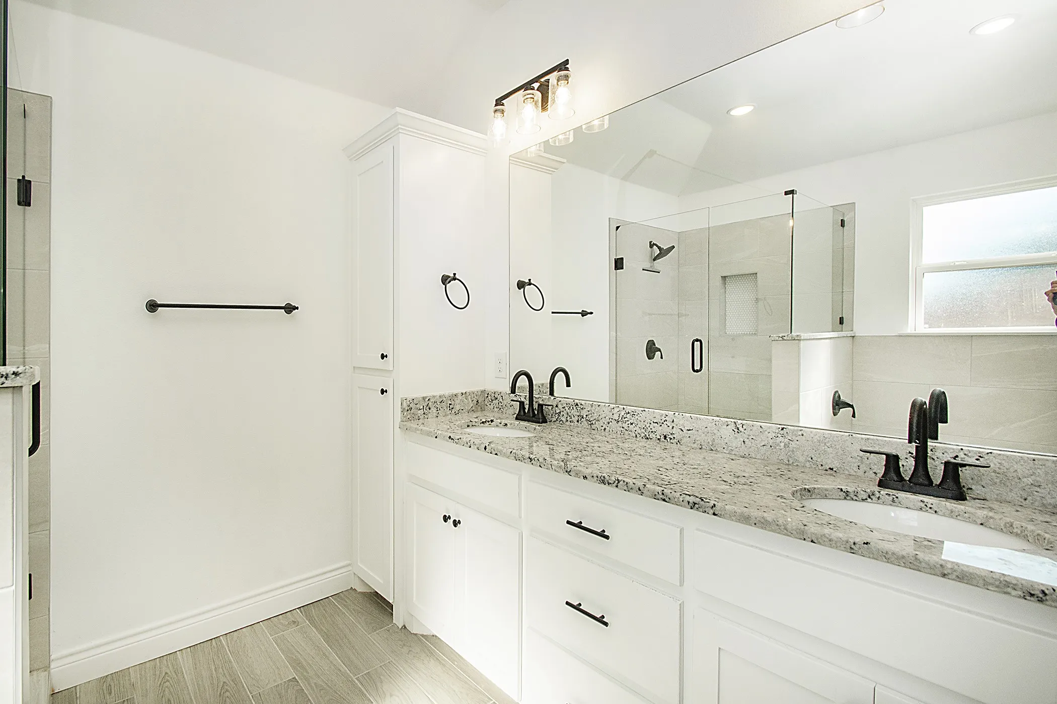 Dual vanity with speckled countertops, dark bronze fixtures, and integrated sinks