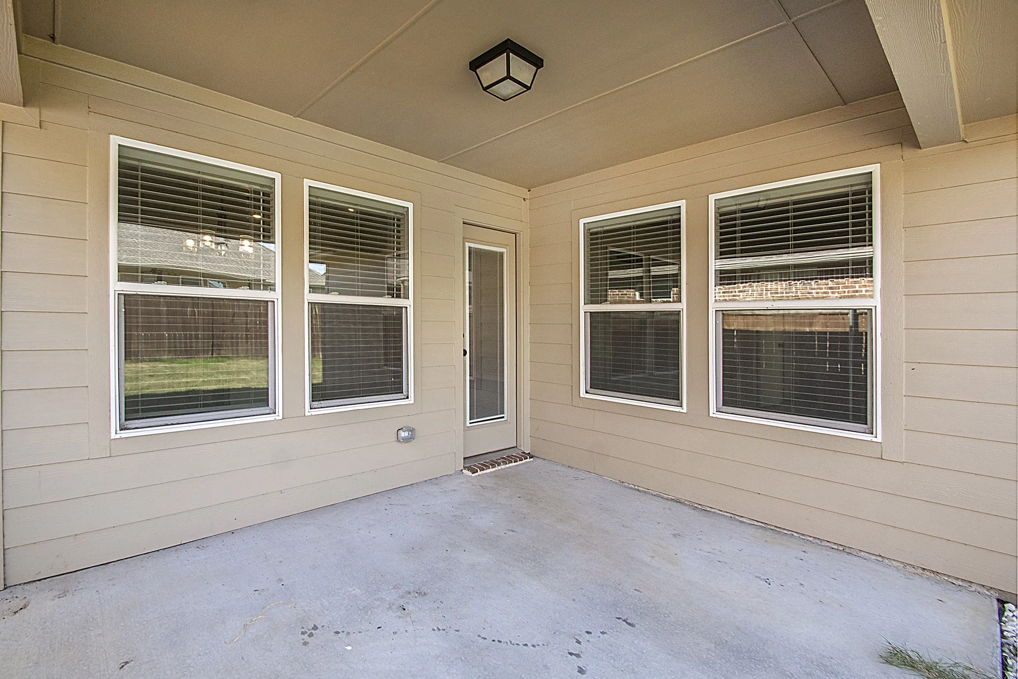 Covered patio with concrete flooring, recessed lighting, and a screened door
