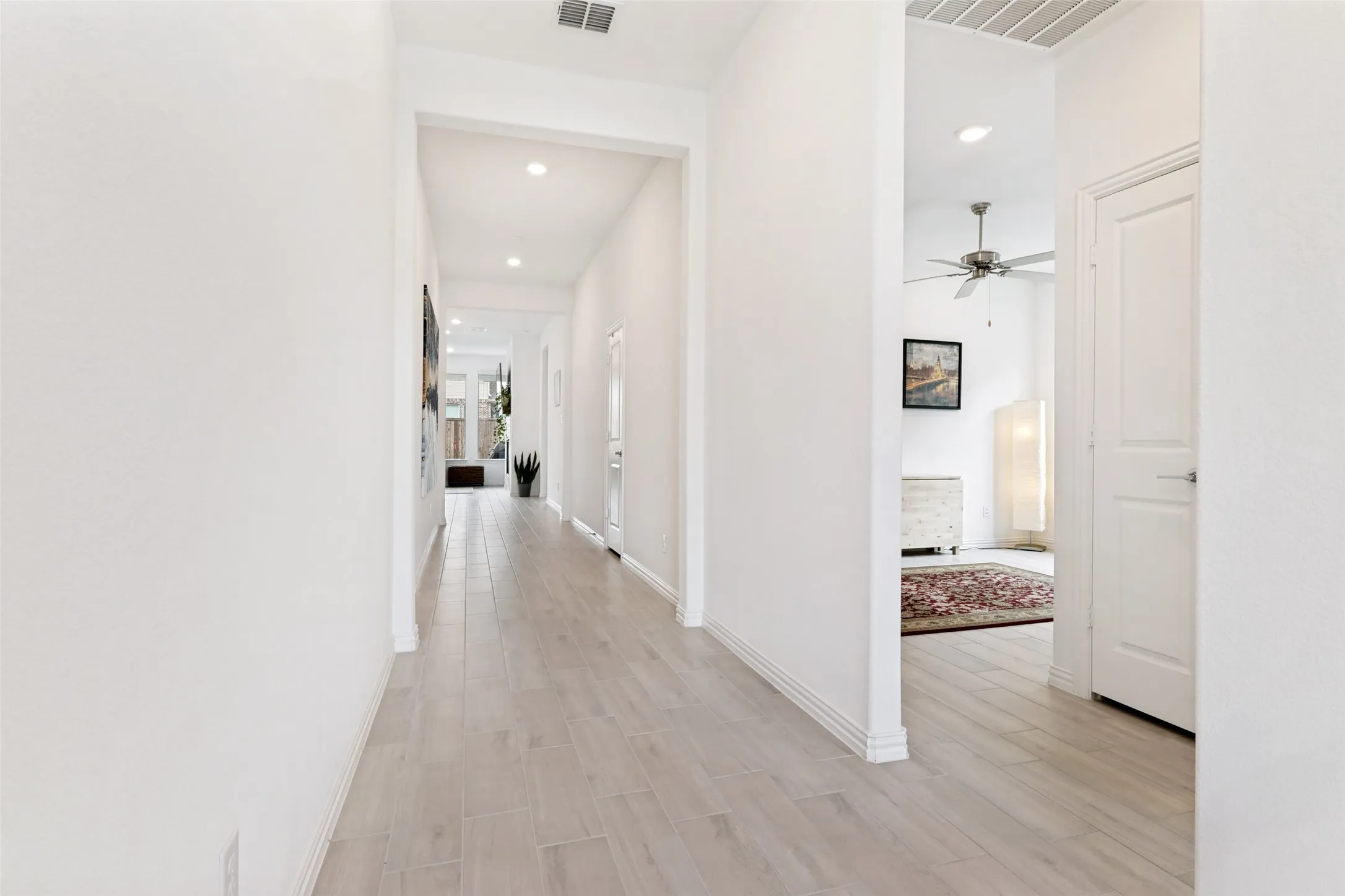Hallway featuring wood-finish flooring, recessed lighting, and white paneled doors