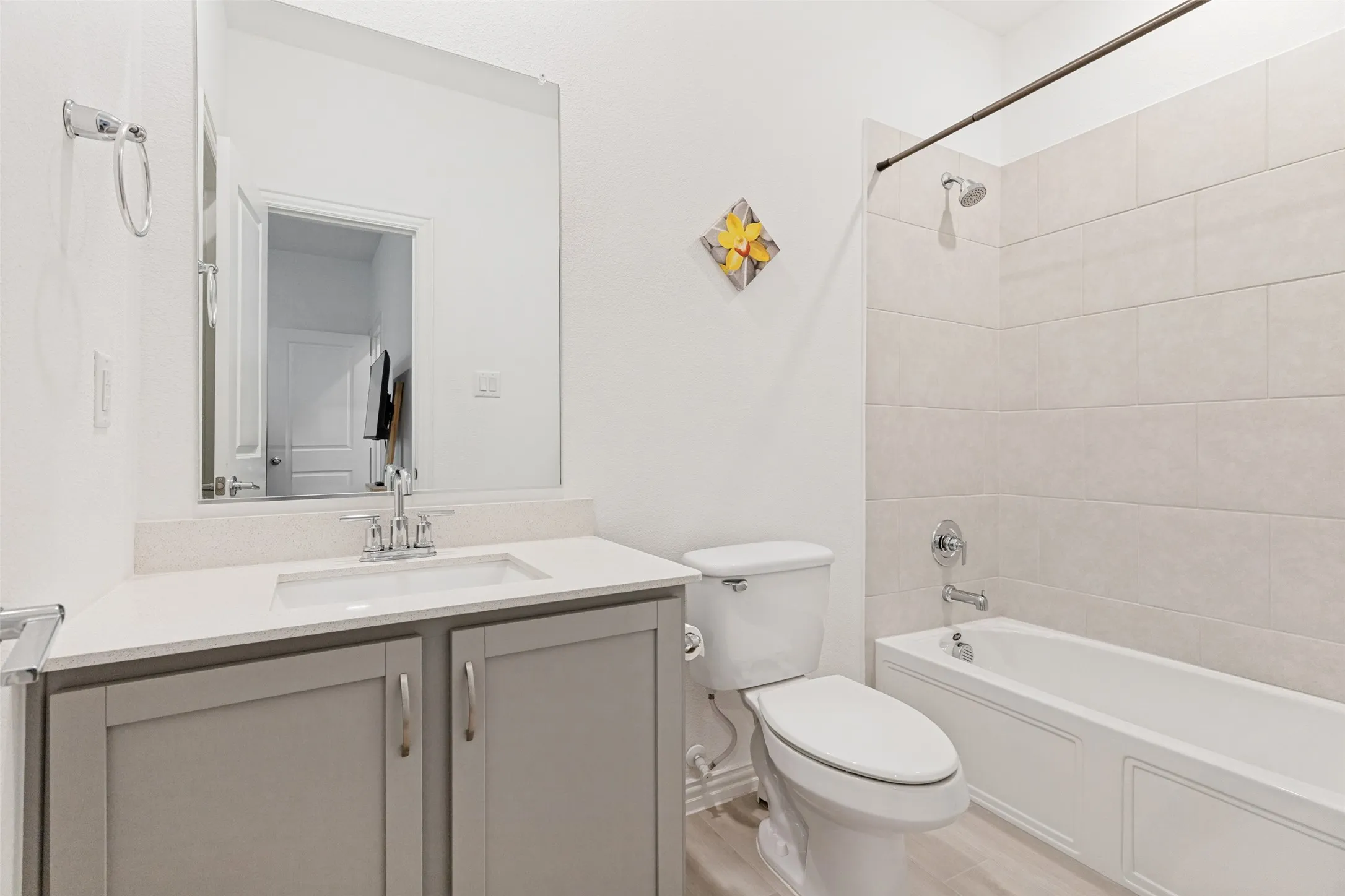 White vanity with a rectangular undermount sink, a chrome faucet, and a large wall-mounted mirror