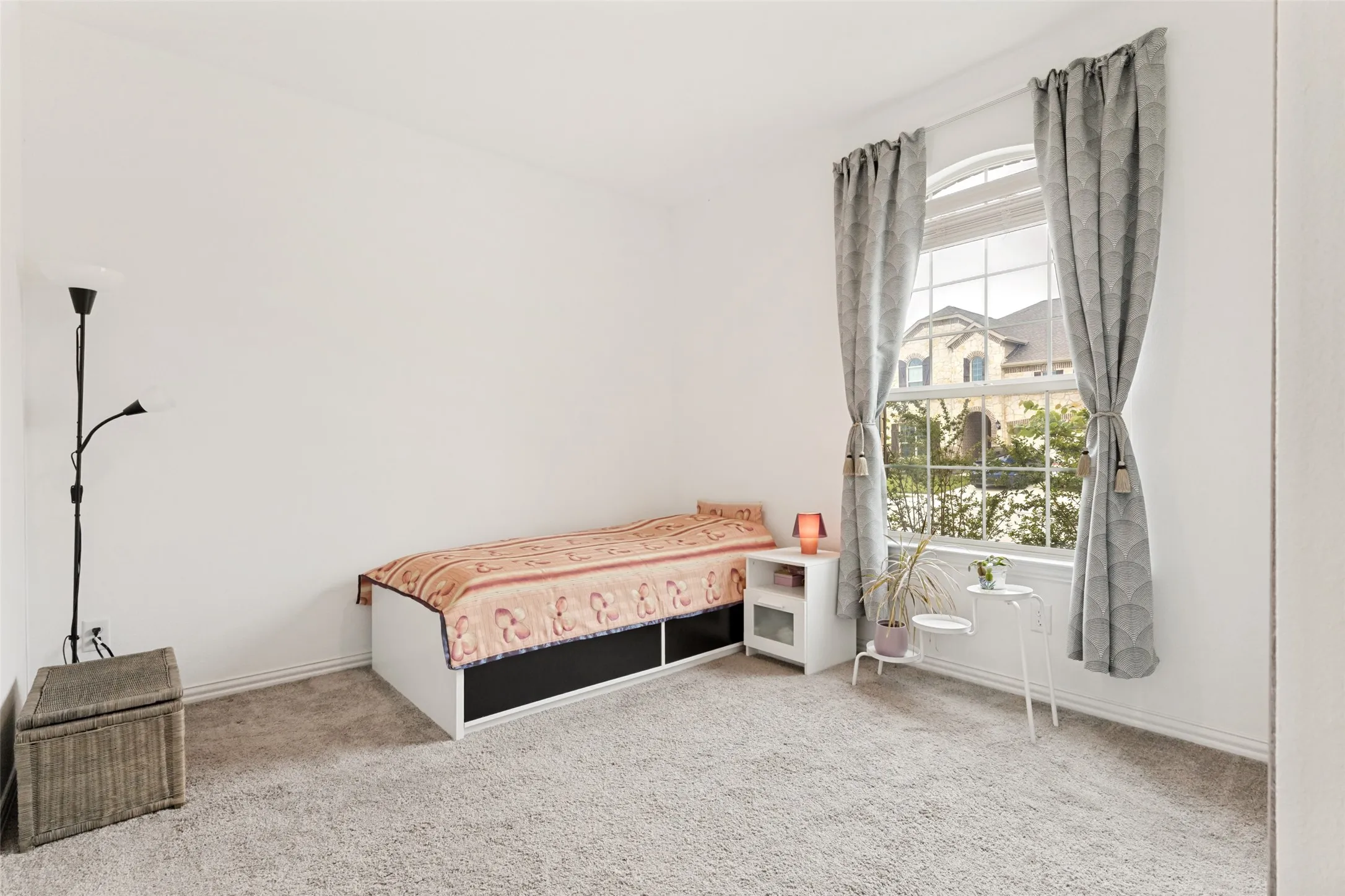 Carpeted flooring, white walls, and a large window with an arched transom