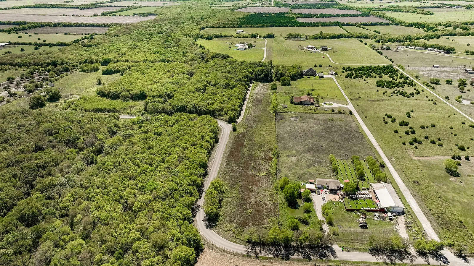 Expansive land featuring wooded areas and cleared fields