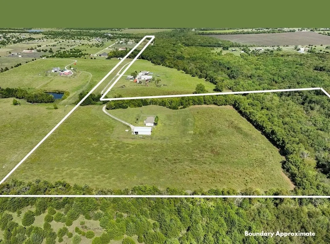 Expansive property featuring a combination of open fields and densely wooded areas