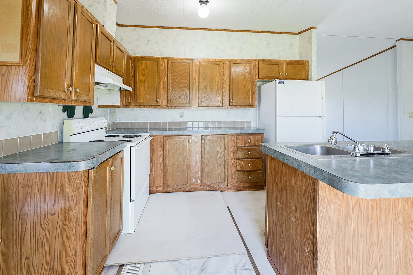 Kitchen featuring wood-finish cabinetry, laminate countertops, and a stainless steel sink