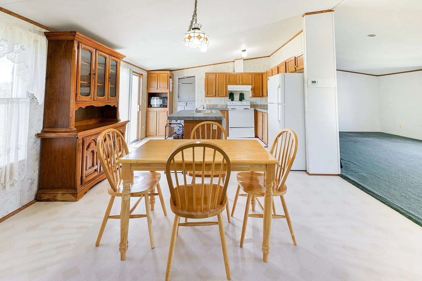 Kitchen area featuring wood-finish cabinetry, white appliances, and a built-in kitchen island
