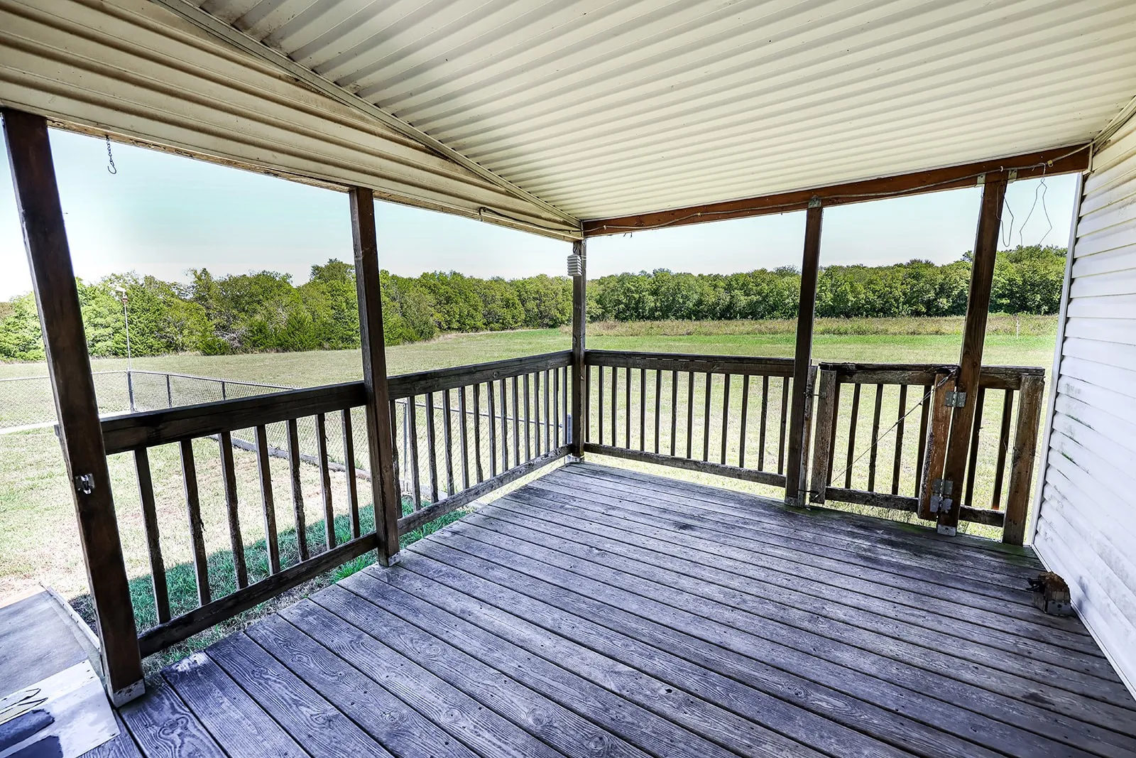 Covered porch with wood flooring and railing
