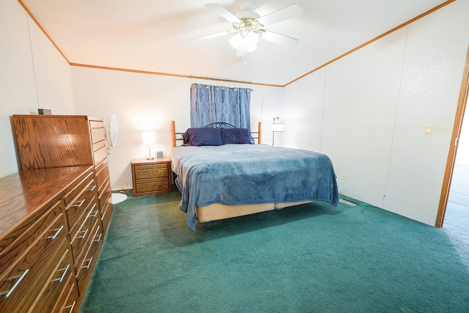 Room featuring wall-to-wall carpeting, white paneling, and wood trim details