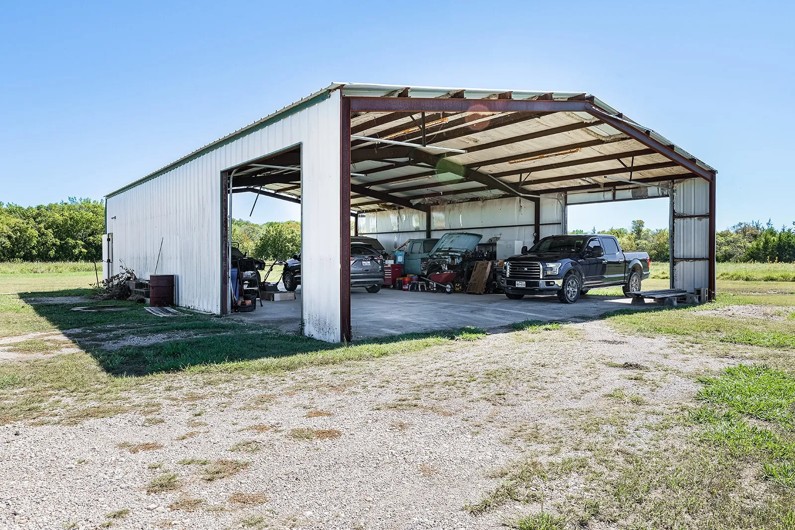 Metal-sided structure with an open bay and overhead door