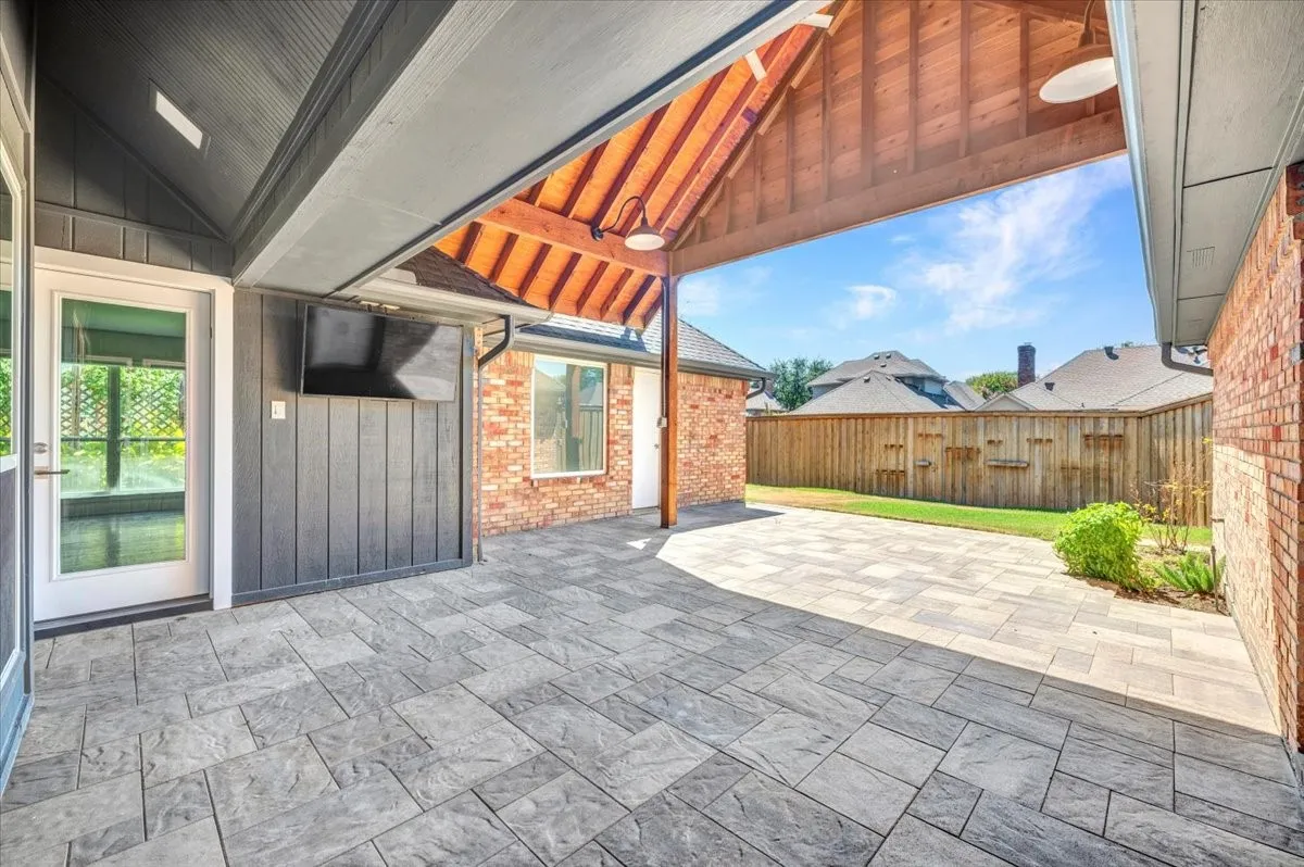 Expansive covered patio featuring a vaulted wood-plank ceiling