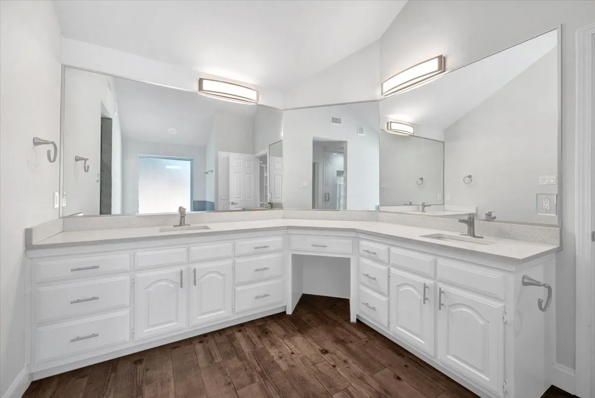 Dual vanity with white cabinetry, light-toned countertops, and integrated sinks