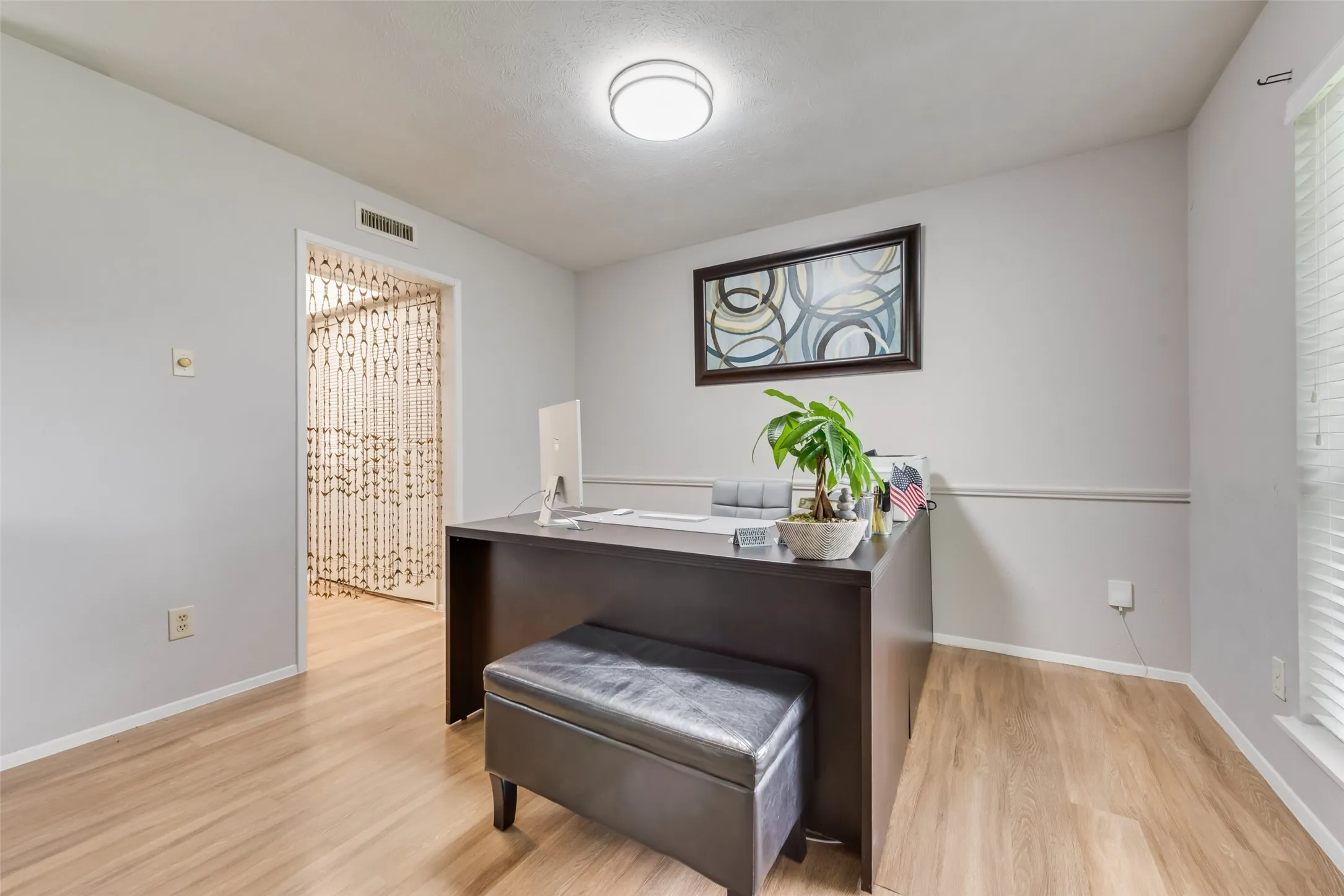 Home office with light wood-type flooring