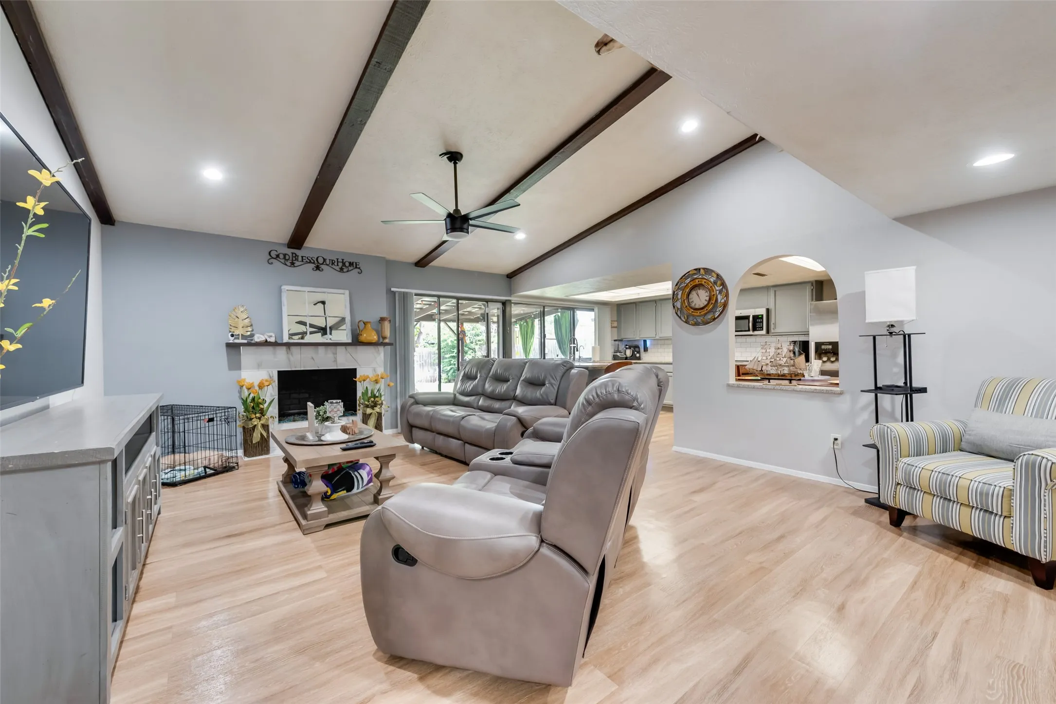 Living area featuring a fireplace, light wood finished floors, ceiling fan, and recessed lighting