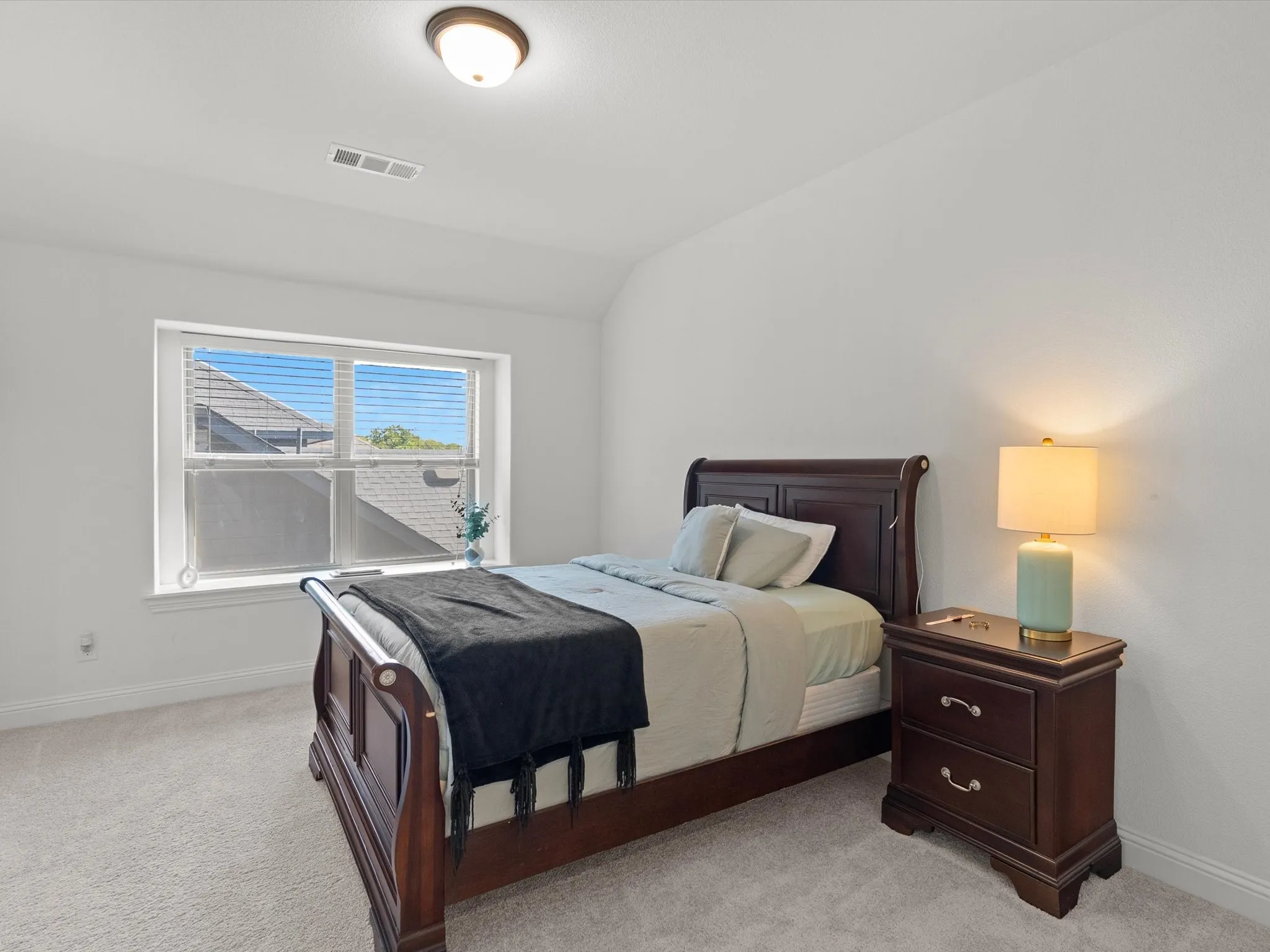 Recessed window with blinds, light-colored carpet, white walls, and a semi-flush mount ceiling light