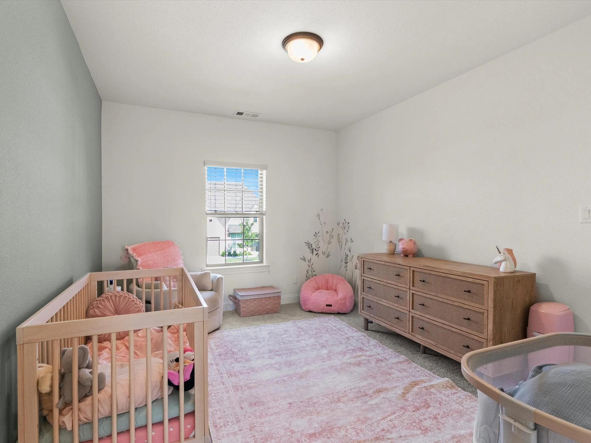 Carpeted room with a single window featuring blinds, a ceiling-mounted light fixture, and two-tone wall finishes