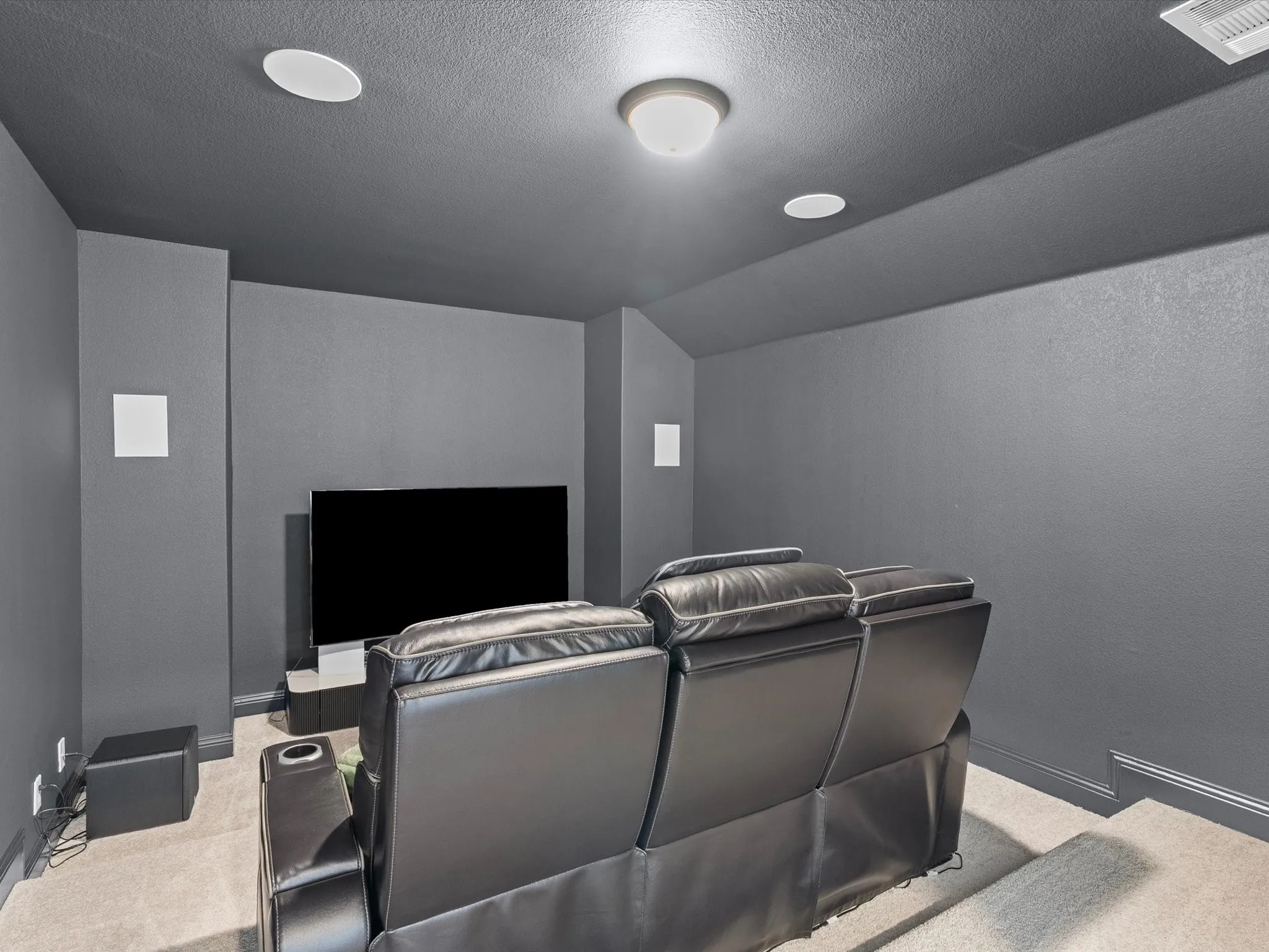 Recessed ceiling lighting, ceiling-mounted light fixture, wall-mounted speakers, and wall-to-wall carpeting