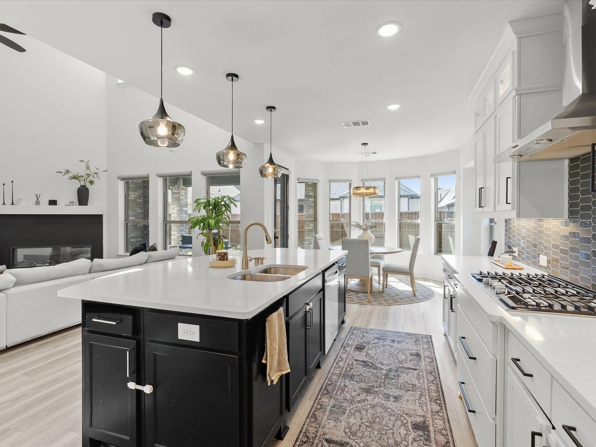 Gourmet kitchen with a large island, stainless steel appliances, and sleek white cabinetry