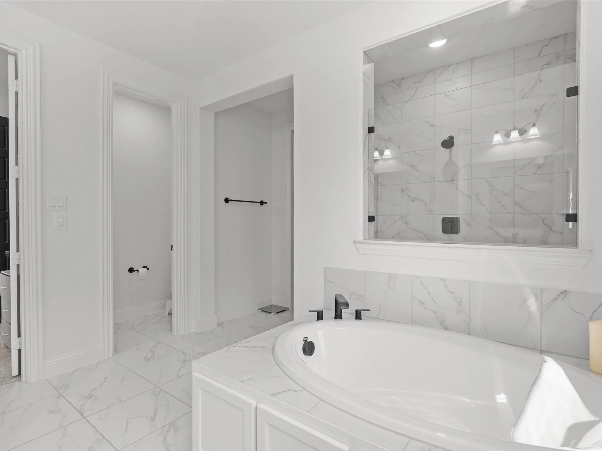 Built-in soaking tub with deck-mounted fixtures, glass-enclosed shower with tiled surround, and extensive tiled flooring
