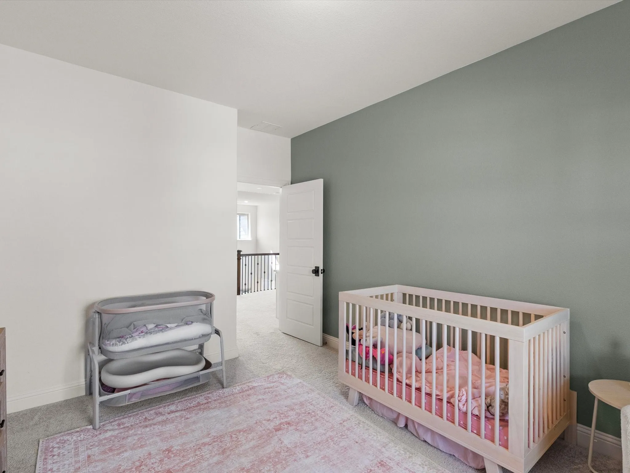 Carpeted room featuring a painted accent wall and a paneled interior door with dark hardware