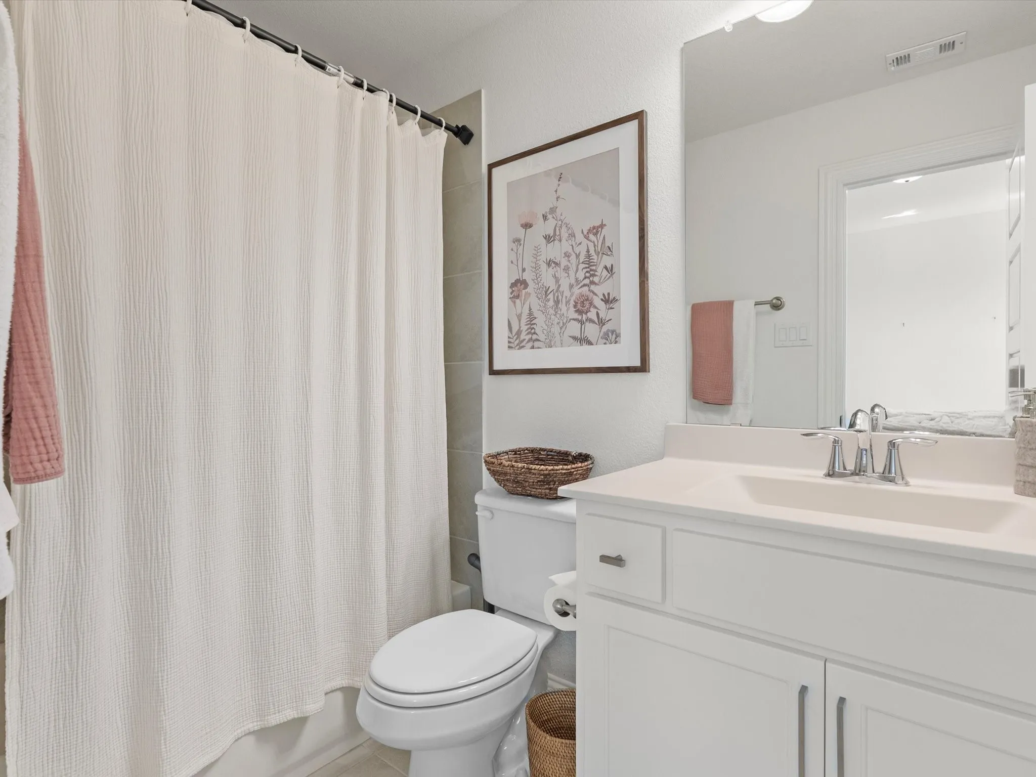 White vanity with integrated sink, chrome faucet, and storage cabinetry