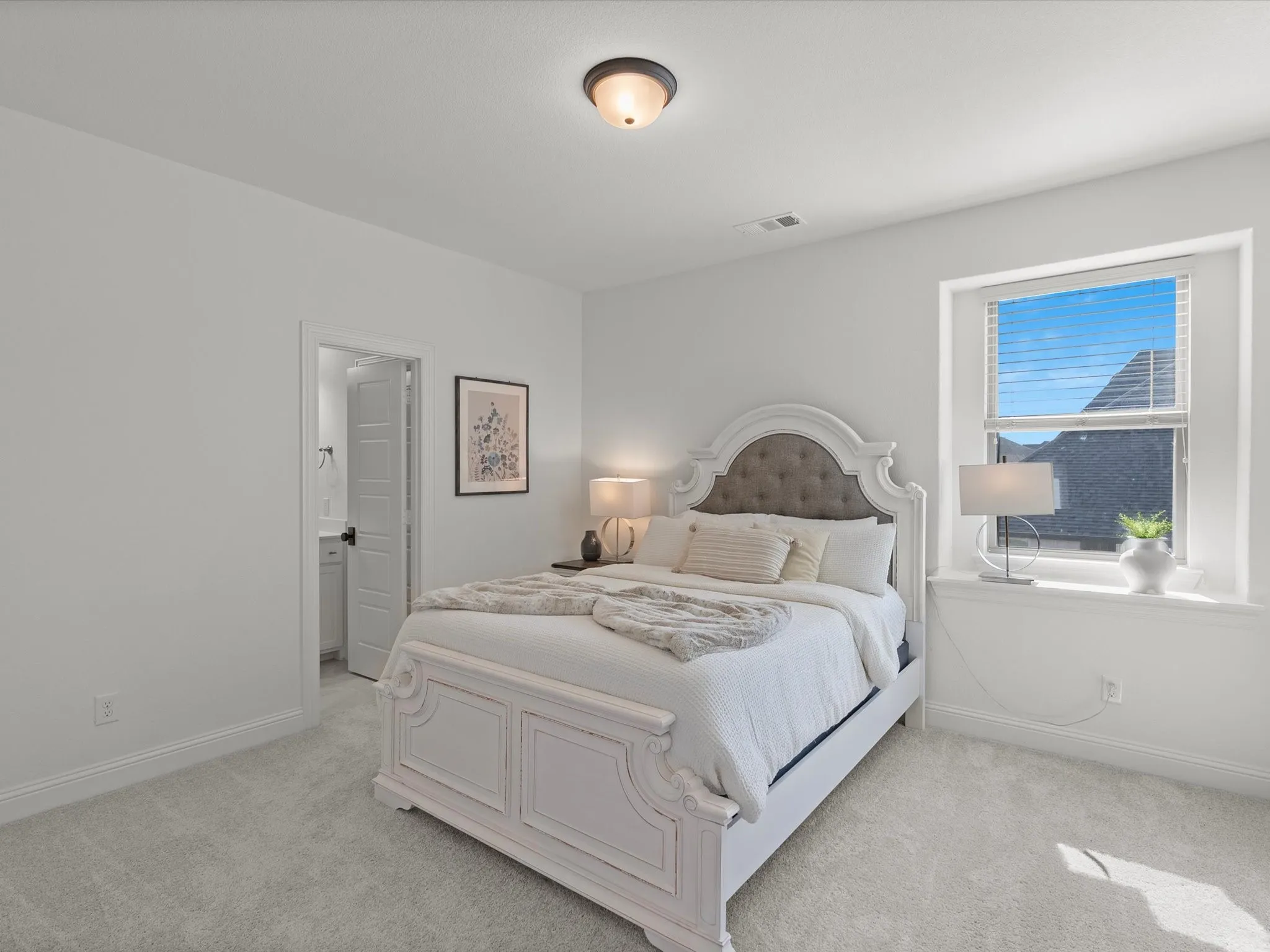 Light gray carpeted flooring, white walls, and a single window with blinds