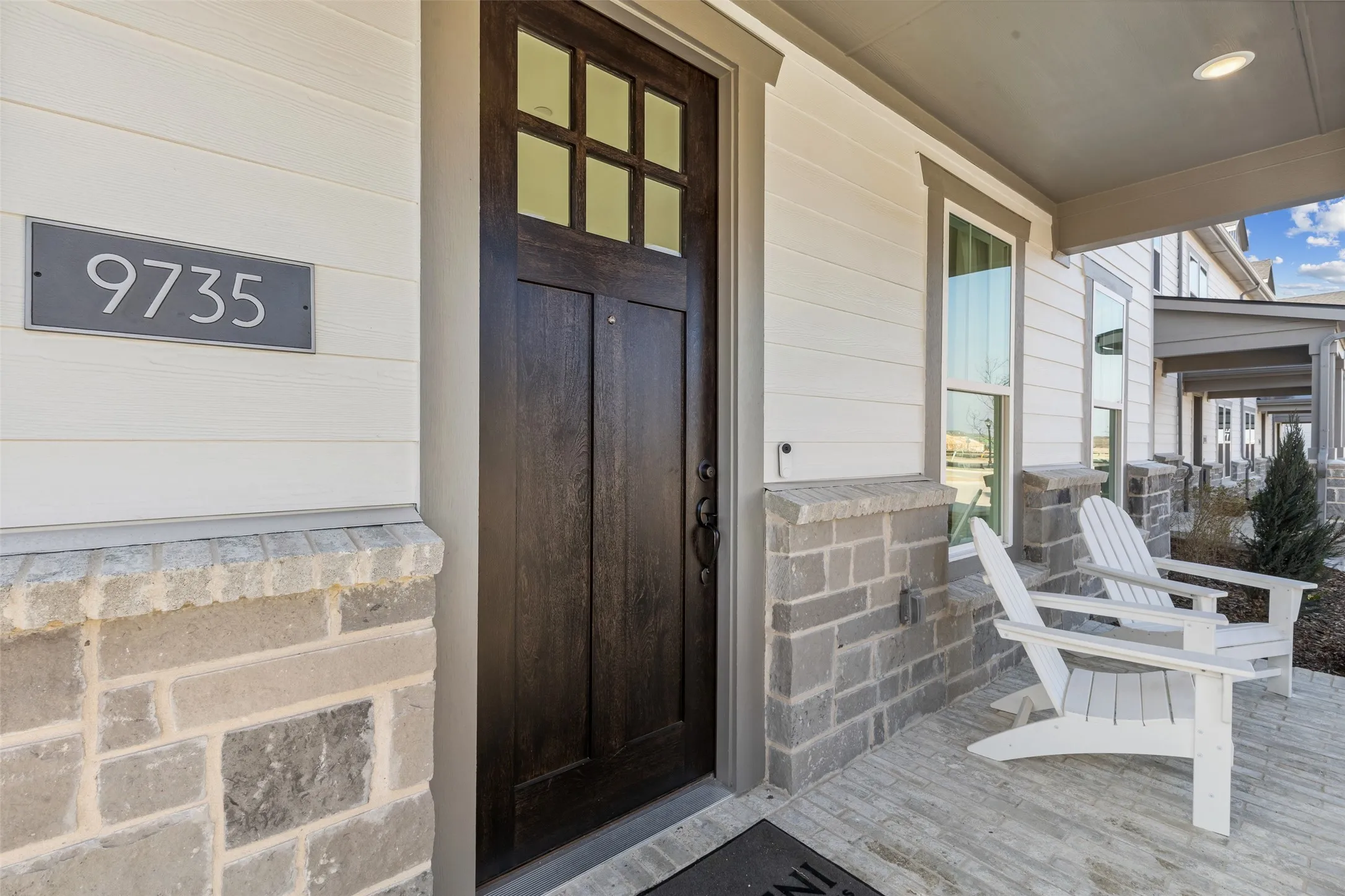 The stone and brick facade with Craftsman front door welcomes friends and family into your new dream home!