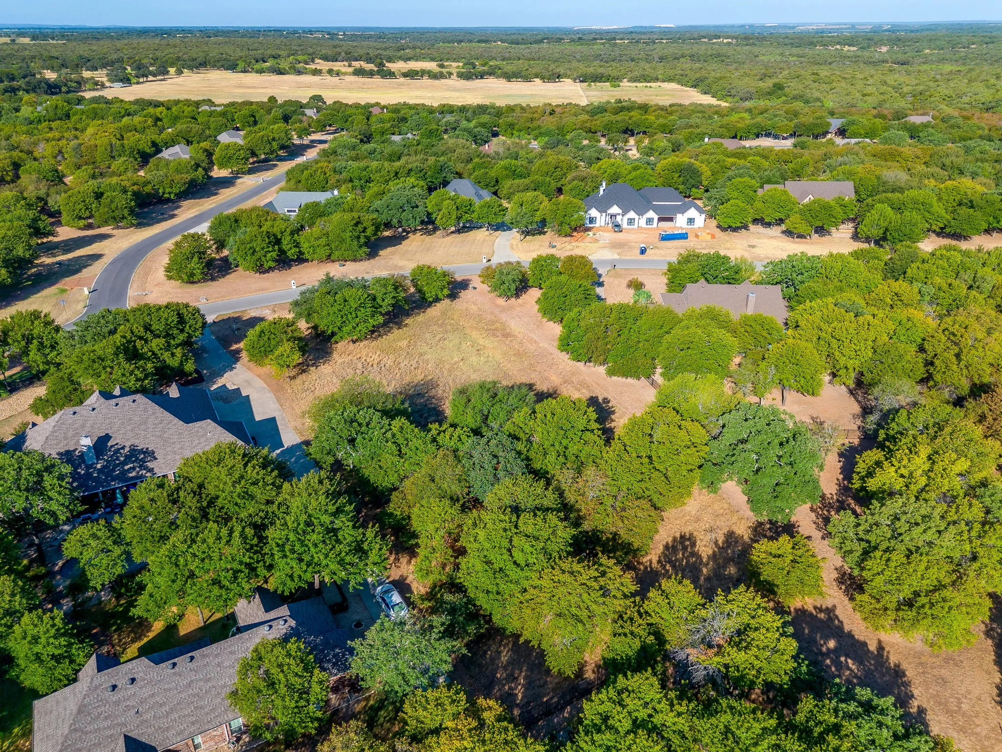 Expansive lot featuring mature trees and a curved driveway