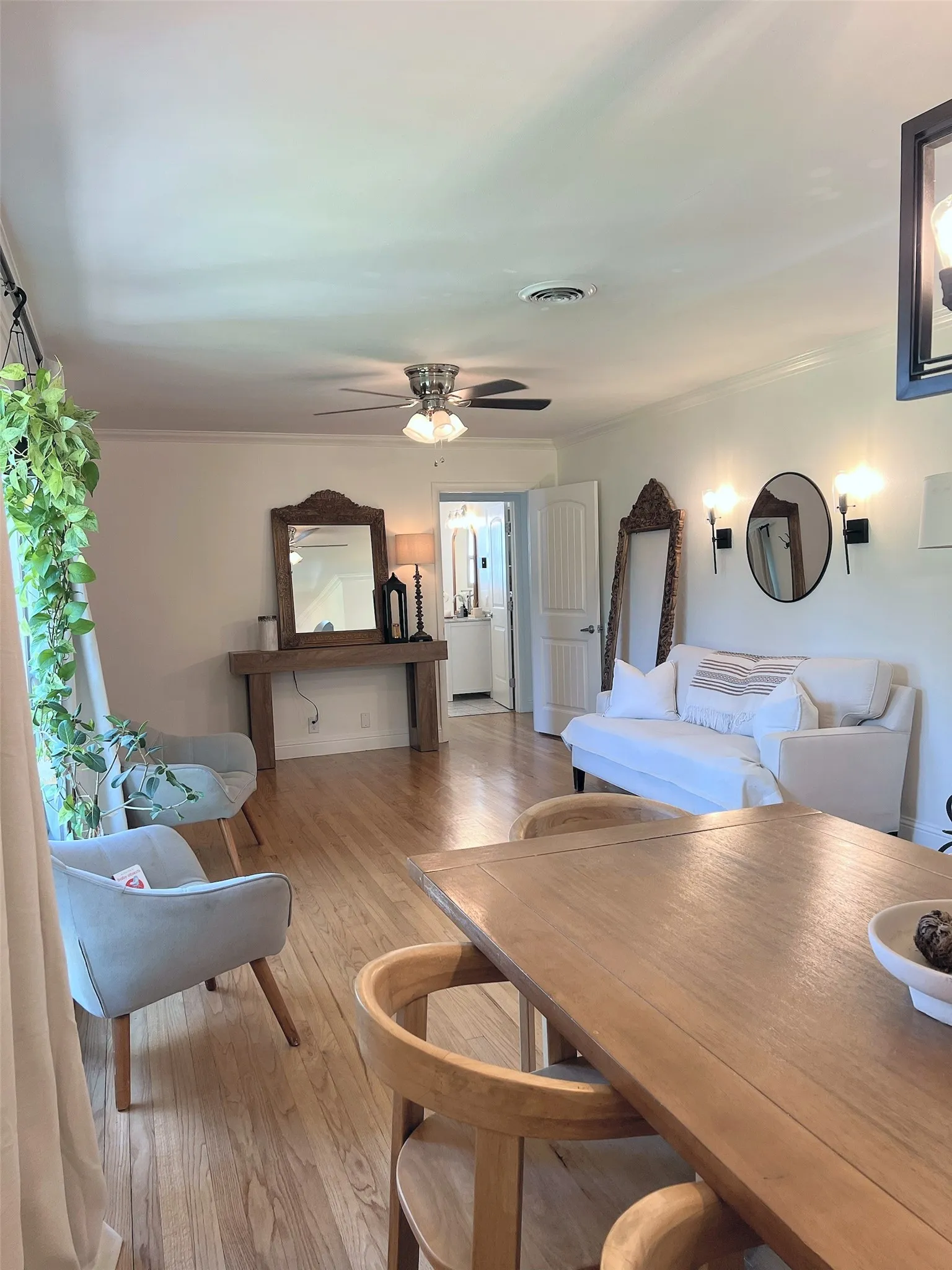 Wood-finish flooring throughout, integrated lighting, wall-mounted sconces, and crown molding