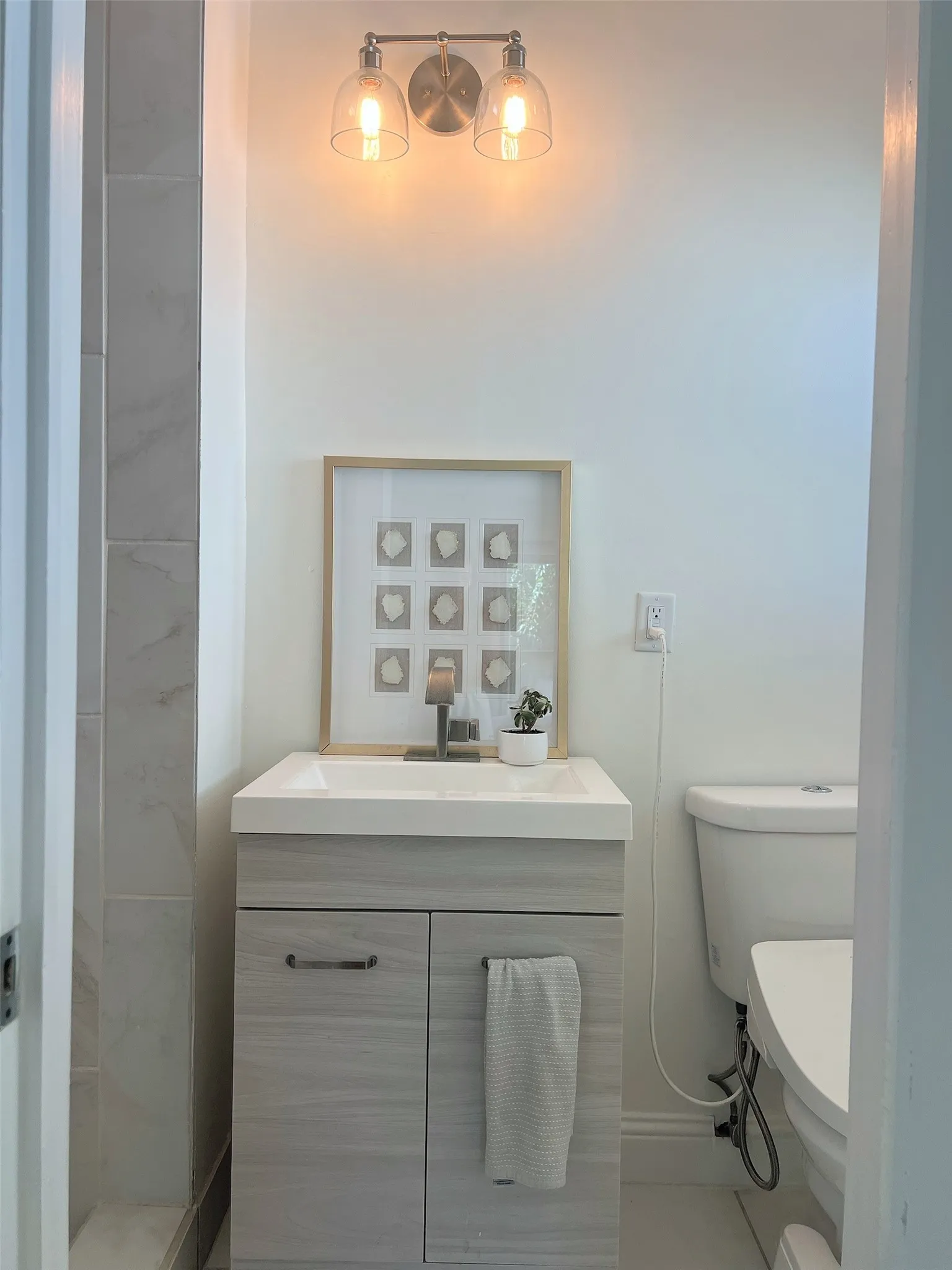 Vanity with integrated sink, wood-style cabinetry, and a single-handle faucet