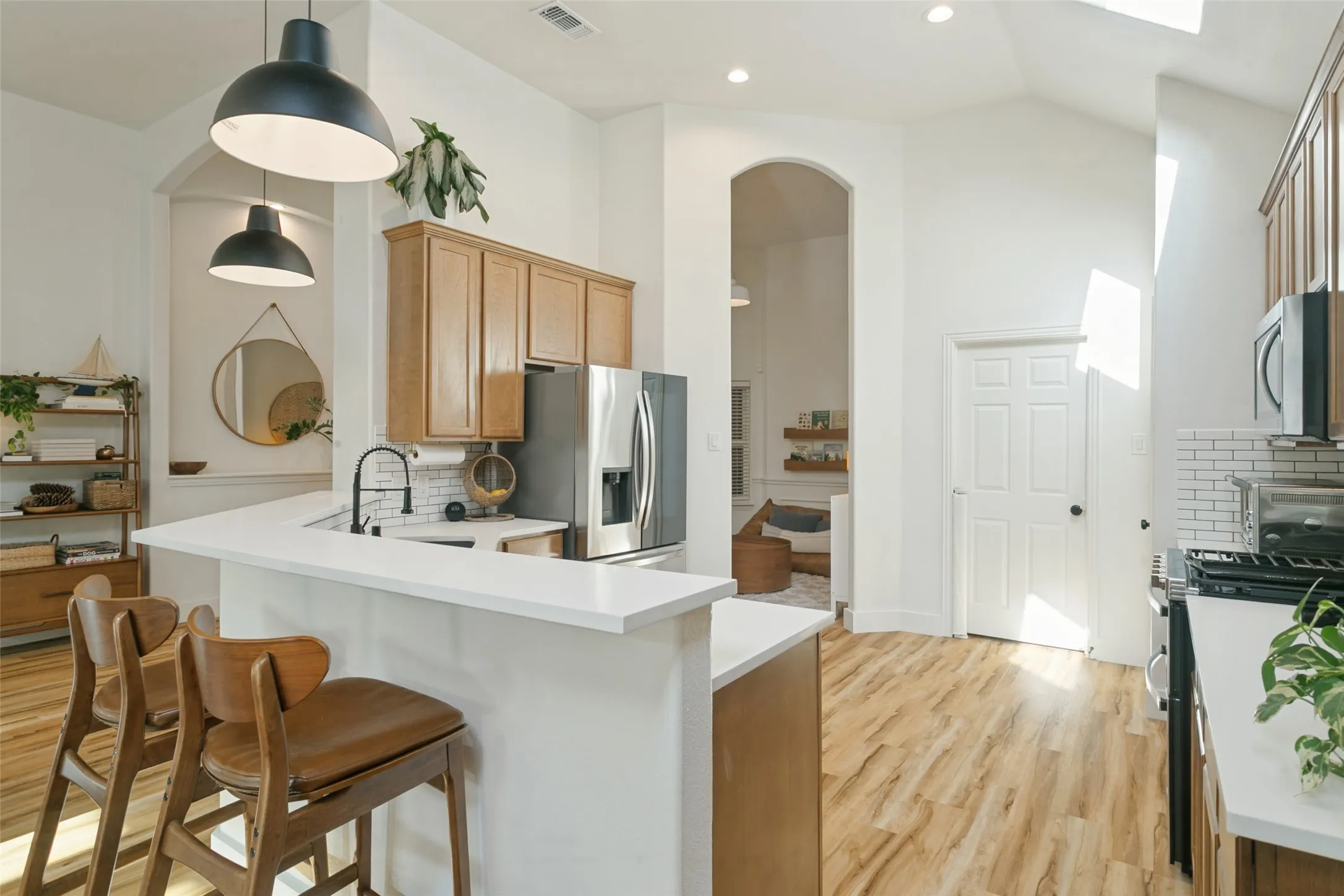 Kitchen featuring a breakfast bar with white countertops, wood-finish flooring, and recessed lighting