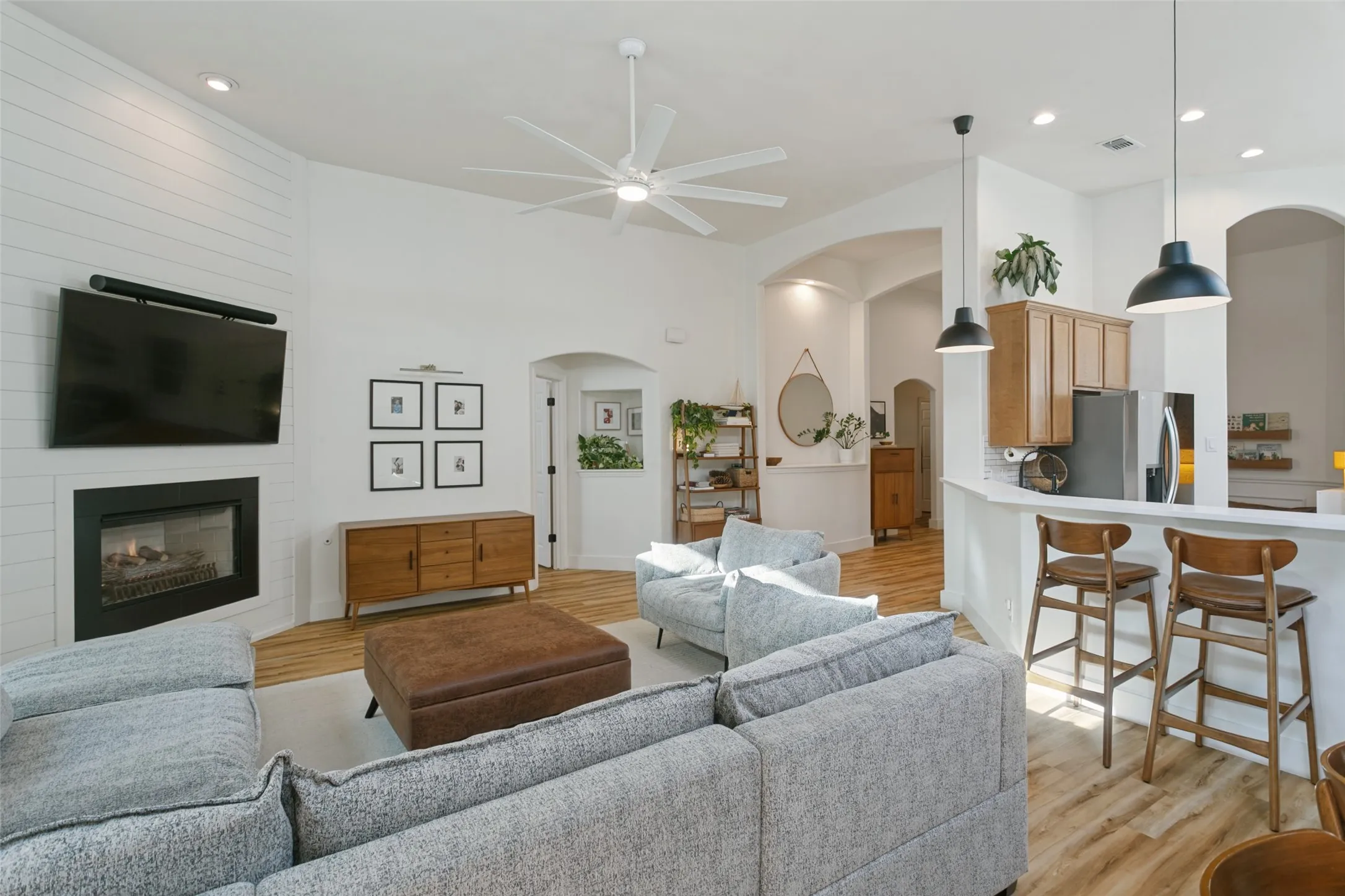Vaulted ceilings, wood-finish flooring, and arched doorways define this space