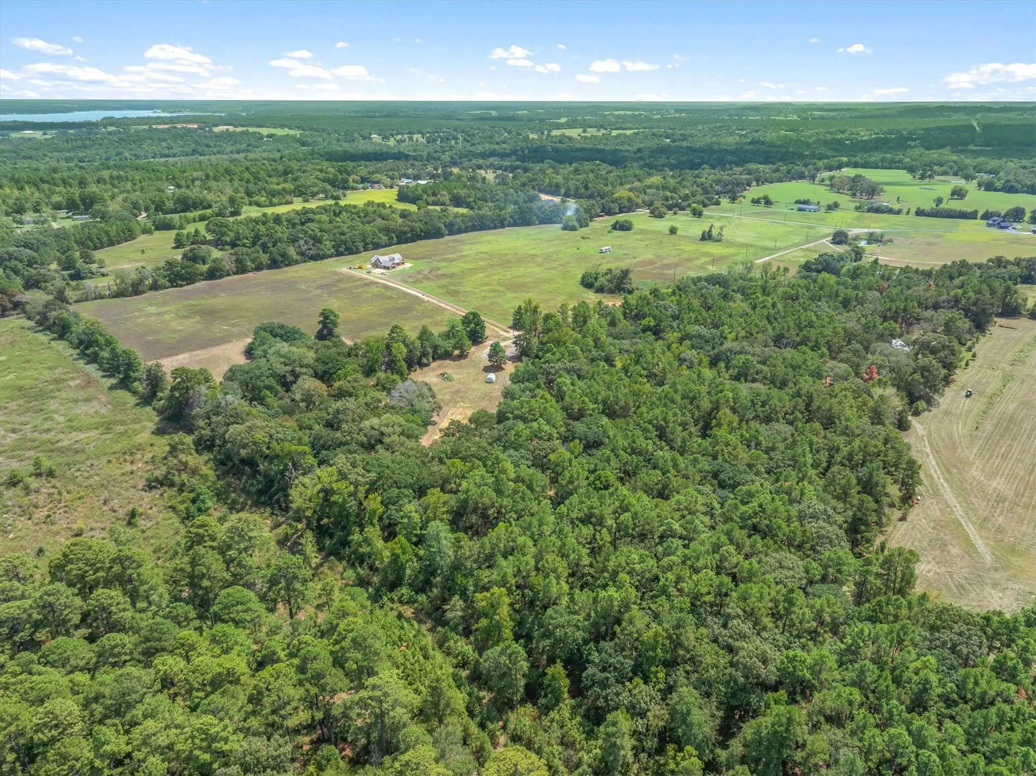 Expansive acreage with mixed woodlands and open fields