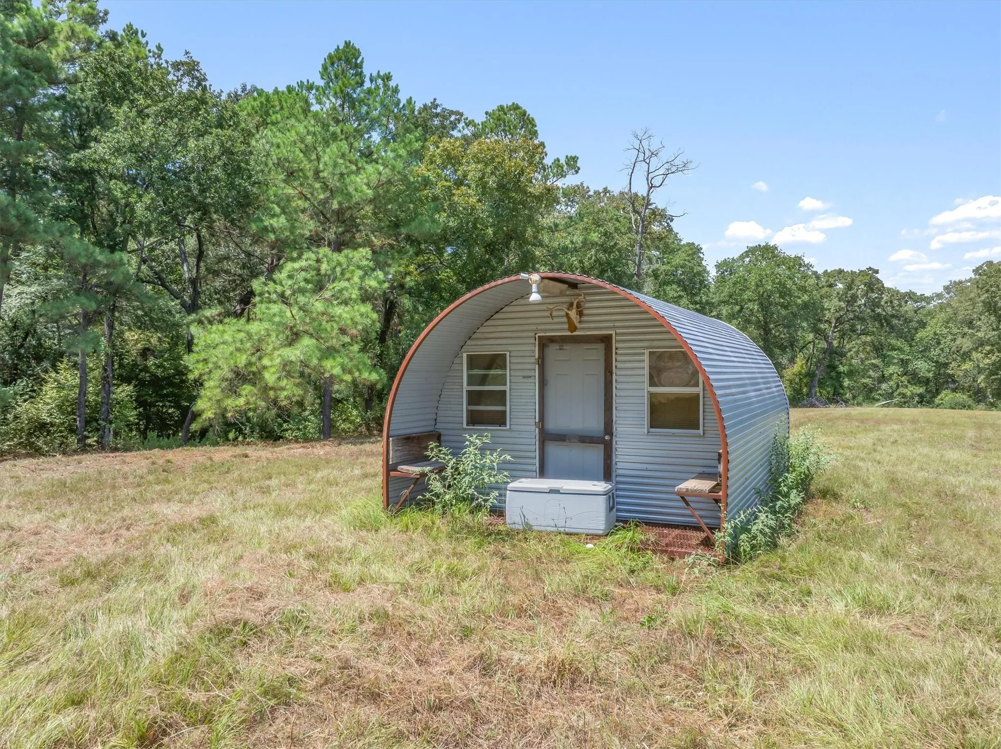 Corrugated metal structure with a single entry door and two windows