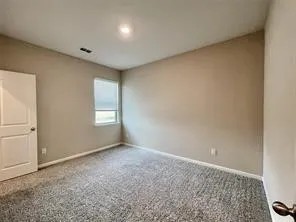 Neutral tone wall paint, recessed ceiling lighting, light gray carpet flooring, white interior door, and window with privacy blind
