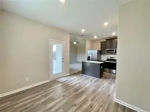 Wood-finish flooring, recessed lighting, and a glass-paneled door
