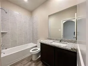 Granite-finish vanity countertop with an integrated sink, dark wood-finish cabinetry, and a full-width wall mirror